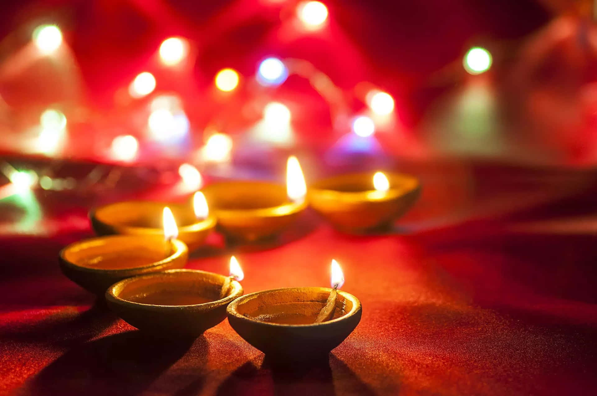 A Group Of Candles Lit Up On A Red Background