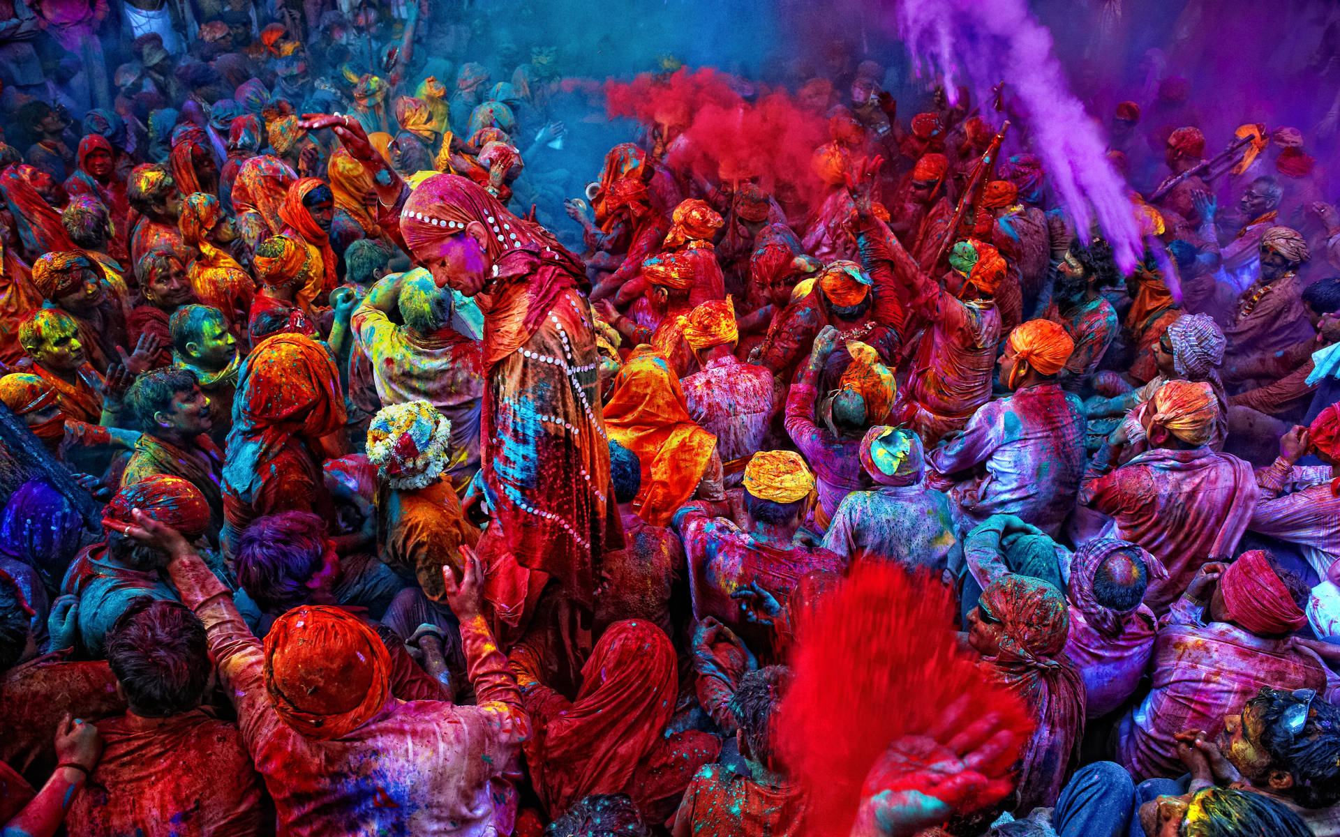 Celebrate vibrancy and joy with this Happy Holi HD image depicting a colorful crowd. Wallpaper