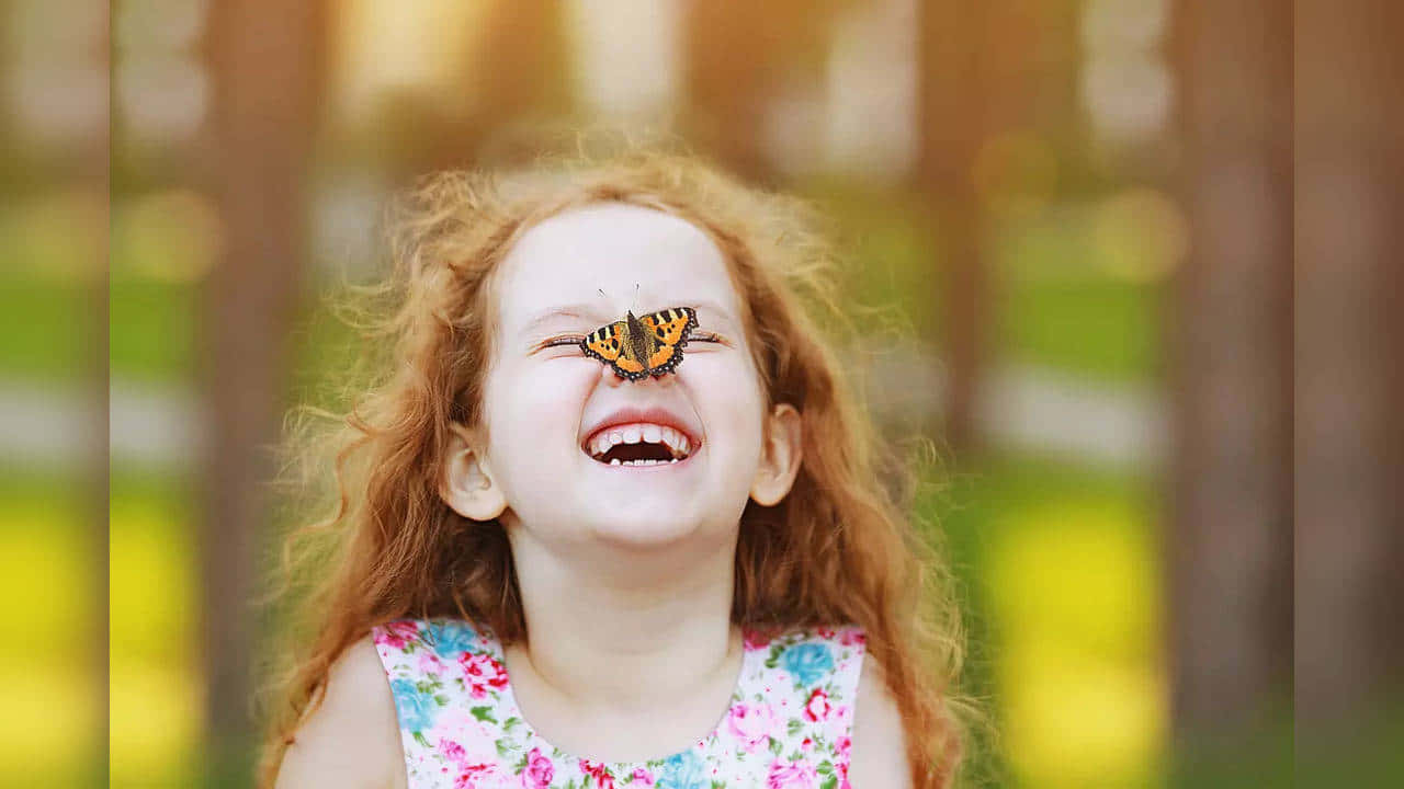 Glade pige med sommerfugl på næsen billed