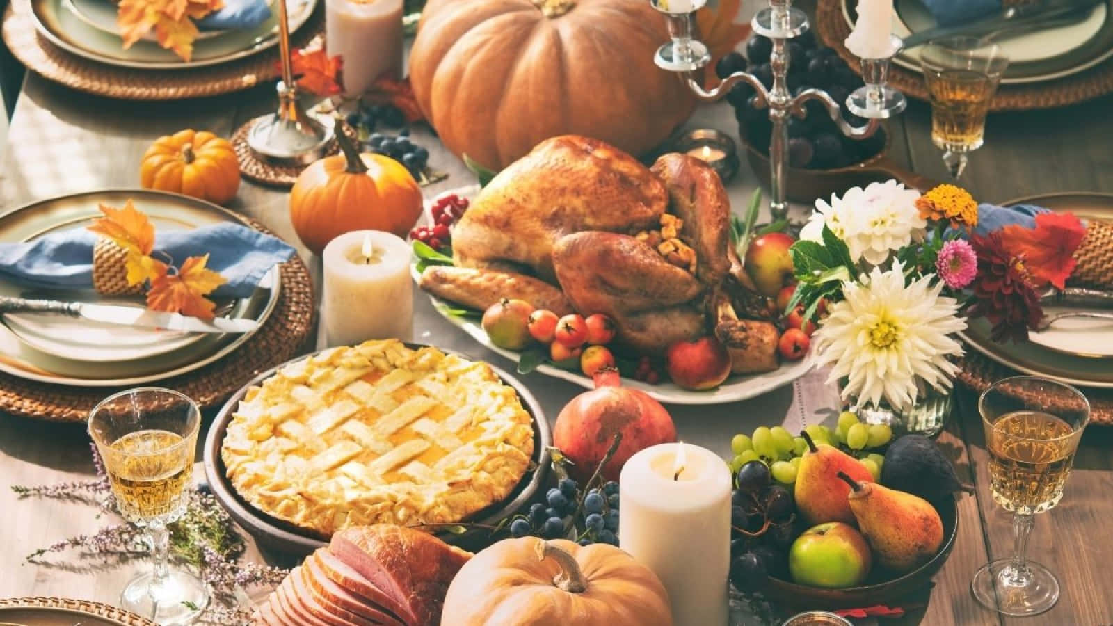 Thanksgiving Table With Turkey, Pumpkins, And Other Food Wallpaper