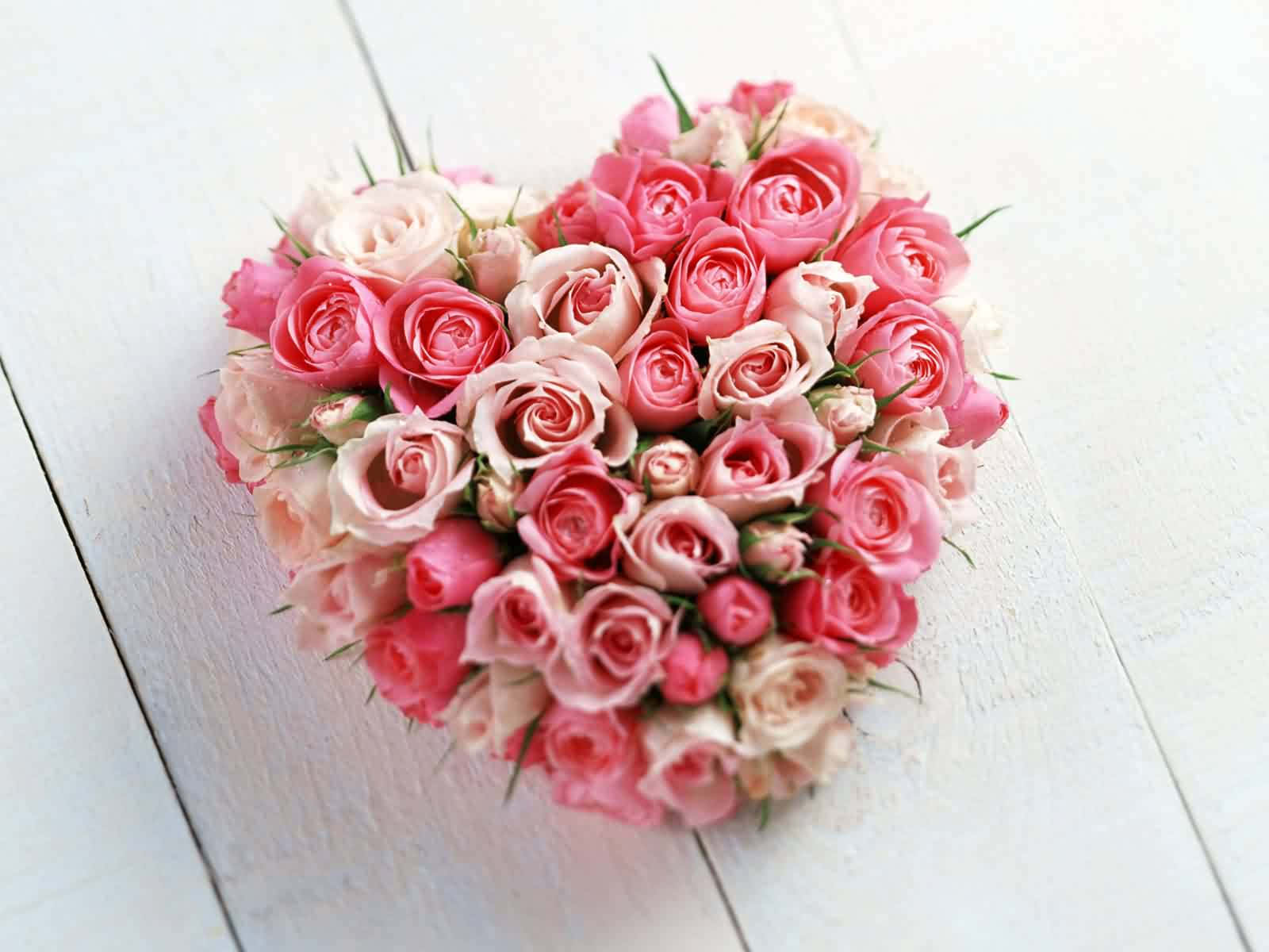 A Heart Shaped Arrangement Of Pink And White Roses