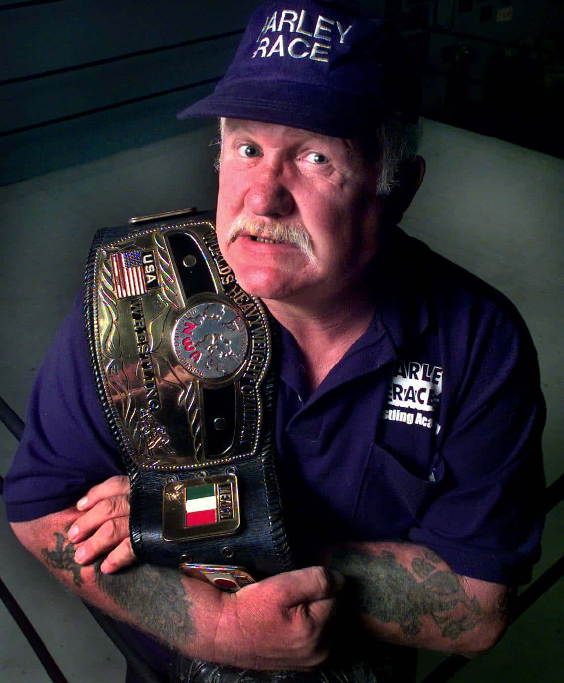 Harley Race Triumphantly Flexing Arms with NWA Championship Belt Wallpaper