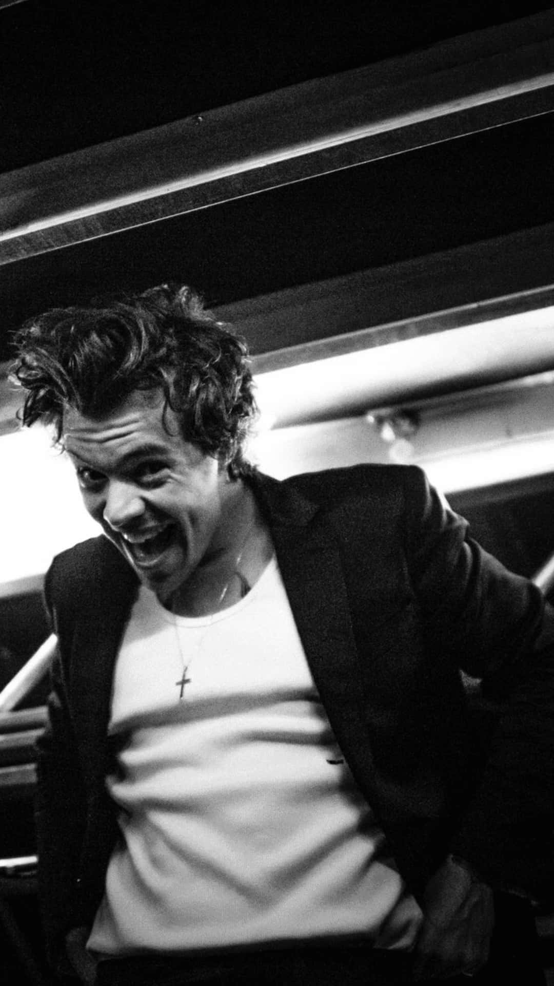 Harry Styles stirrer intenst ind i en dramatisk sort og hvid fotoscene. Wallpaper