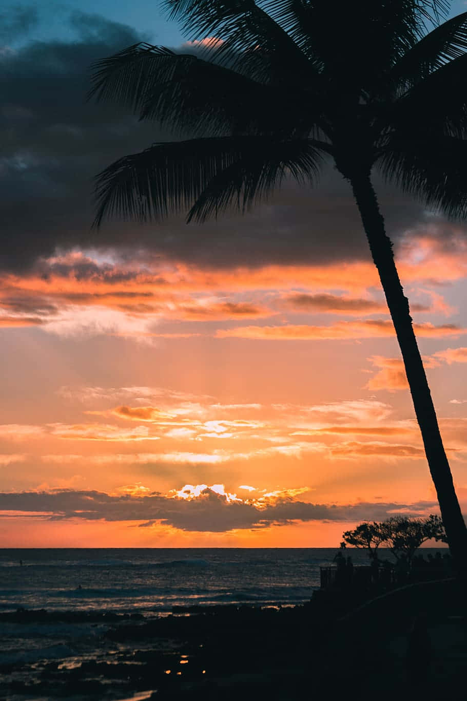 Solen går ned over en smuk strand i Hawaii Wallpaper