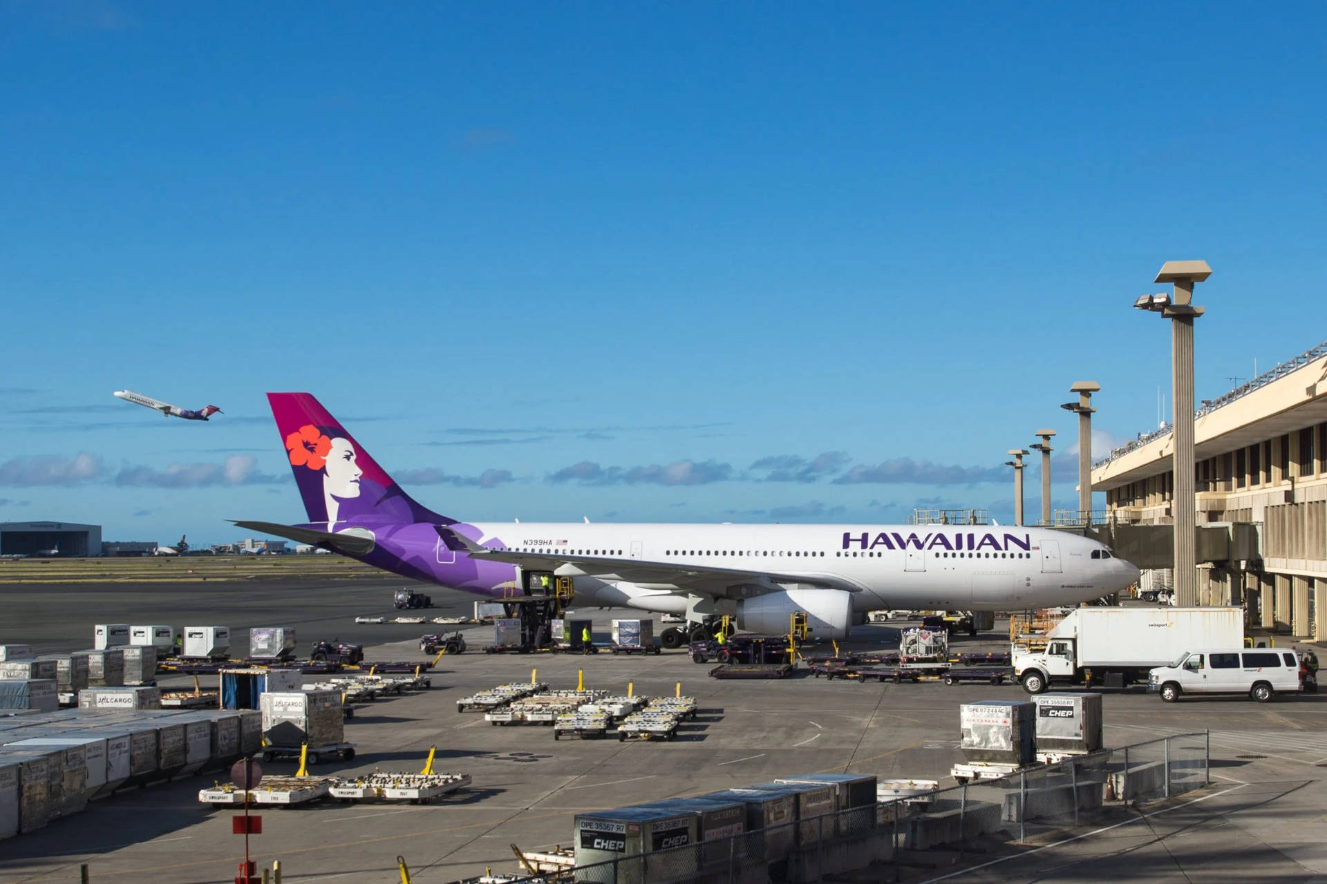 Hawaiian Airlines Plane Amidst A Busy Tarmac Wallpaper