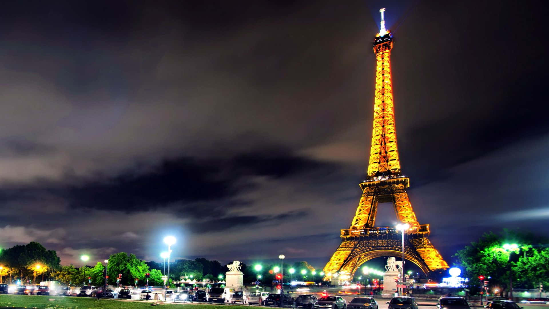 the eiffel tower is lit up at night Wallpaper