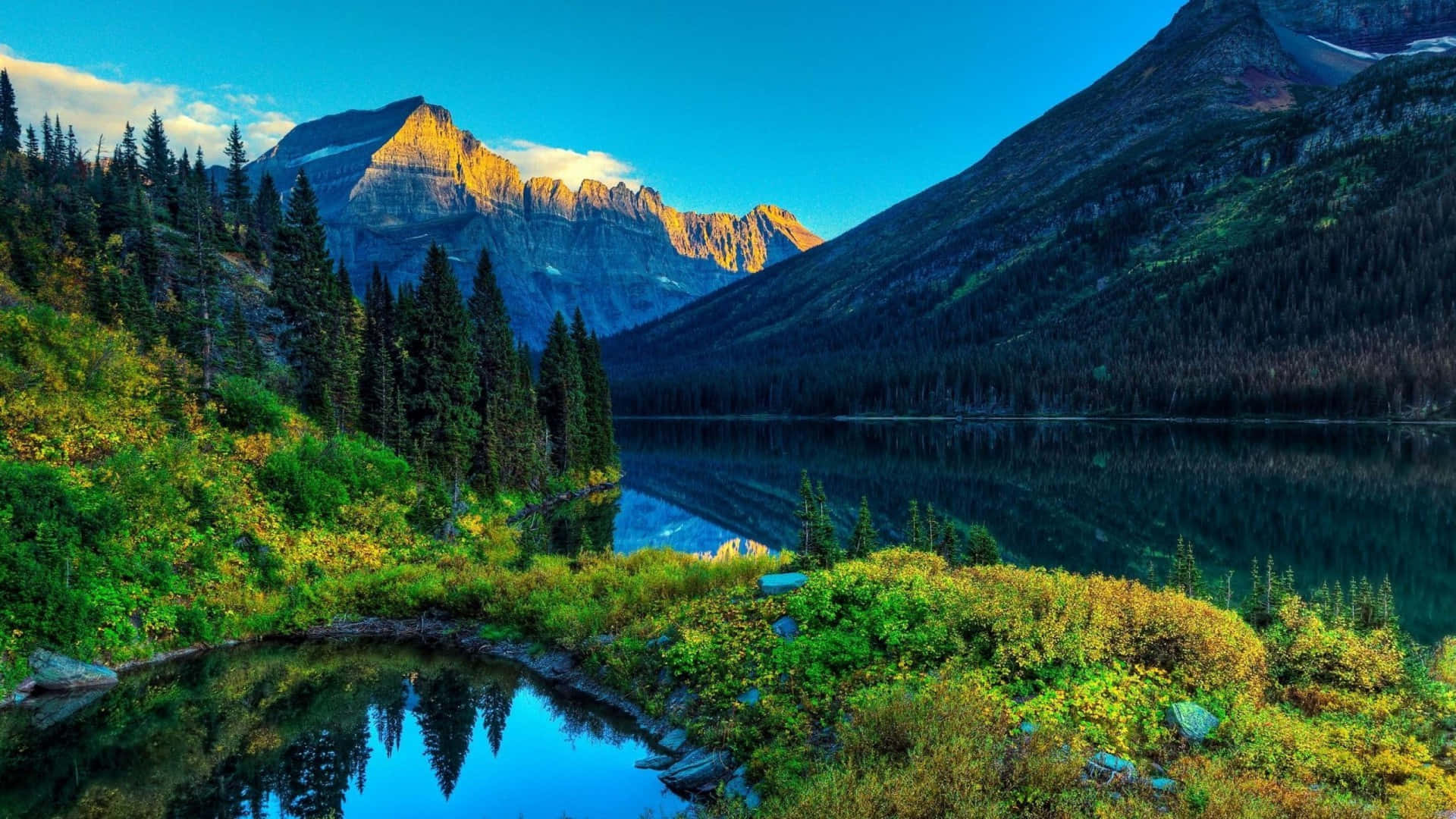 a lake surrounded by mountains and trees Wallpaper