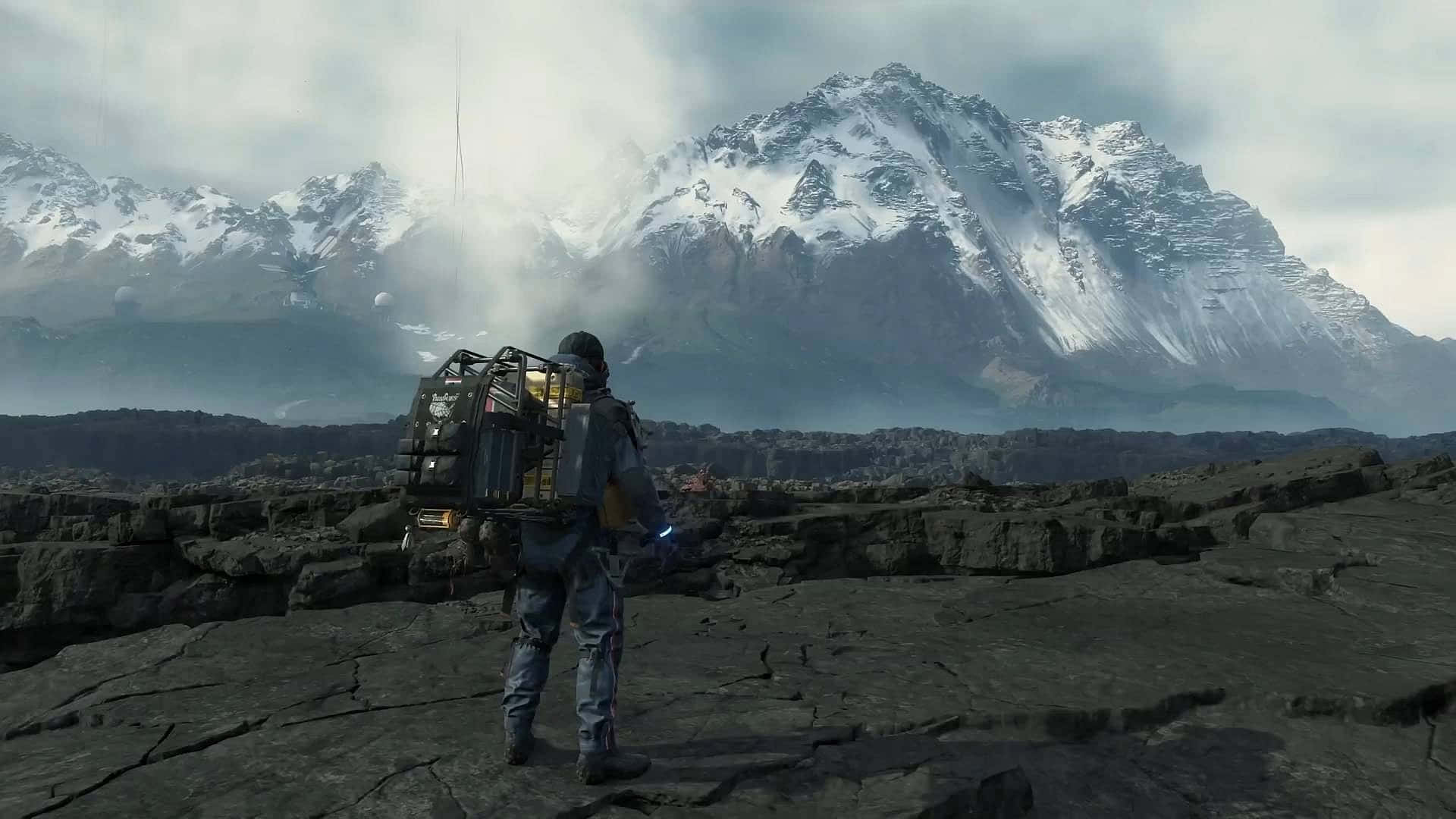 A Man With A Backpack Is Standing In Front Of Mountains