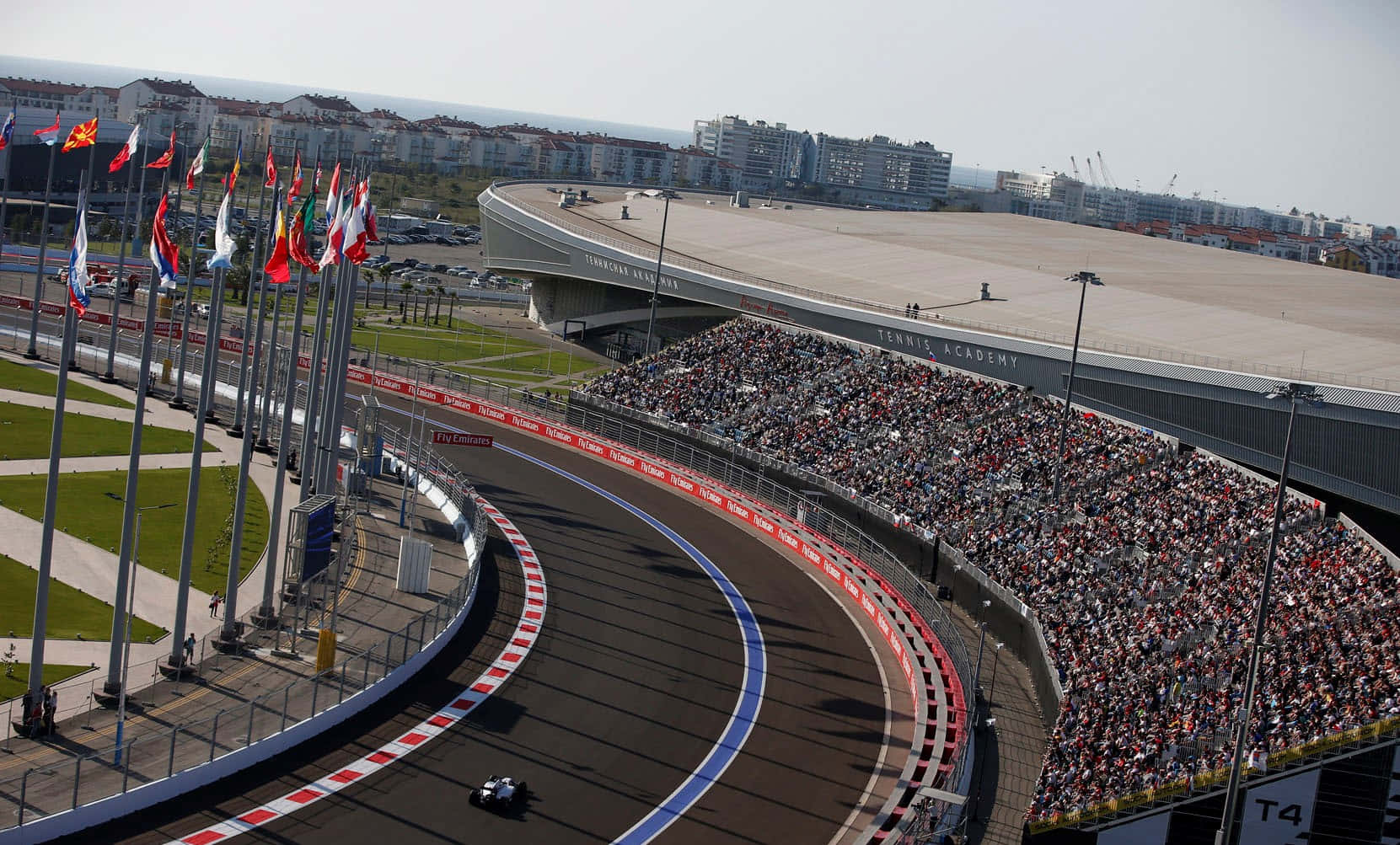 A Race Track With Flags And People Watching