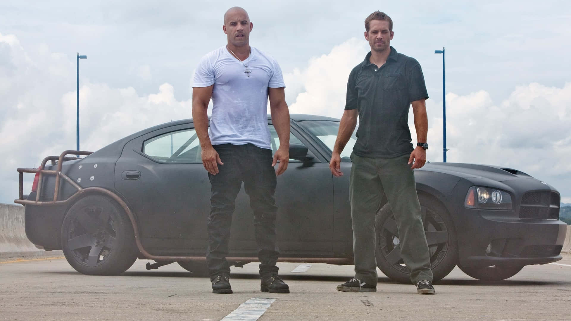 Two Men Standing Next To A Black Car