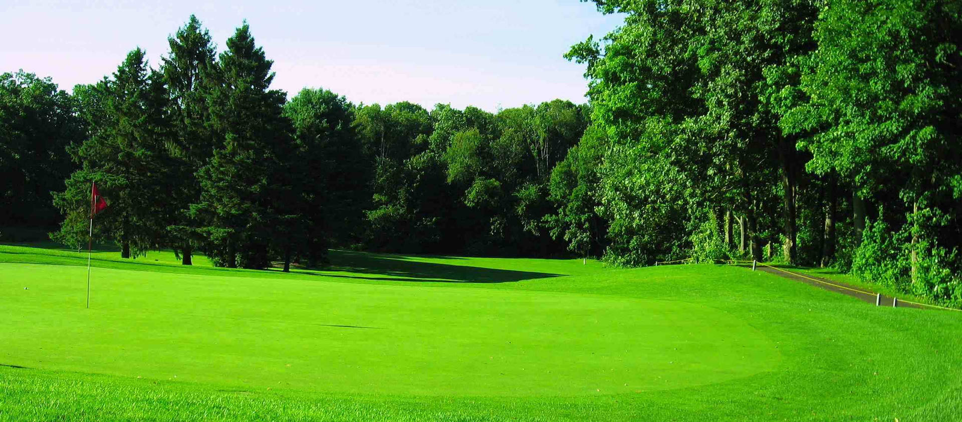 Billede af golfspil på det grønne med en smuk baggrund af frodige bakker. Wallpaper