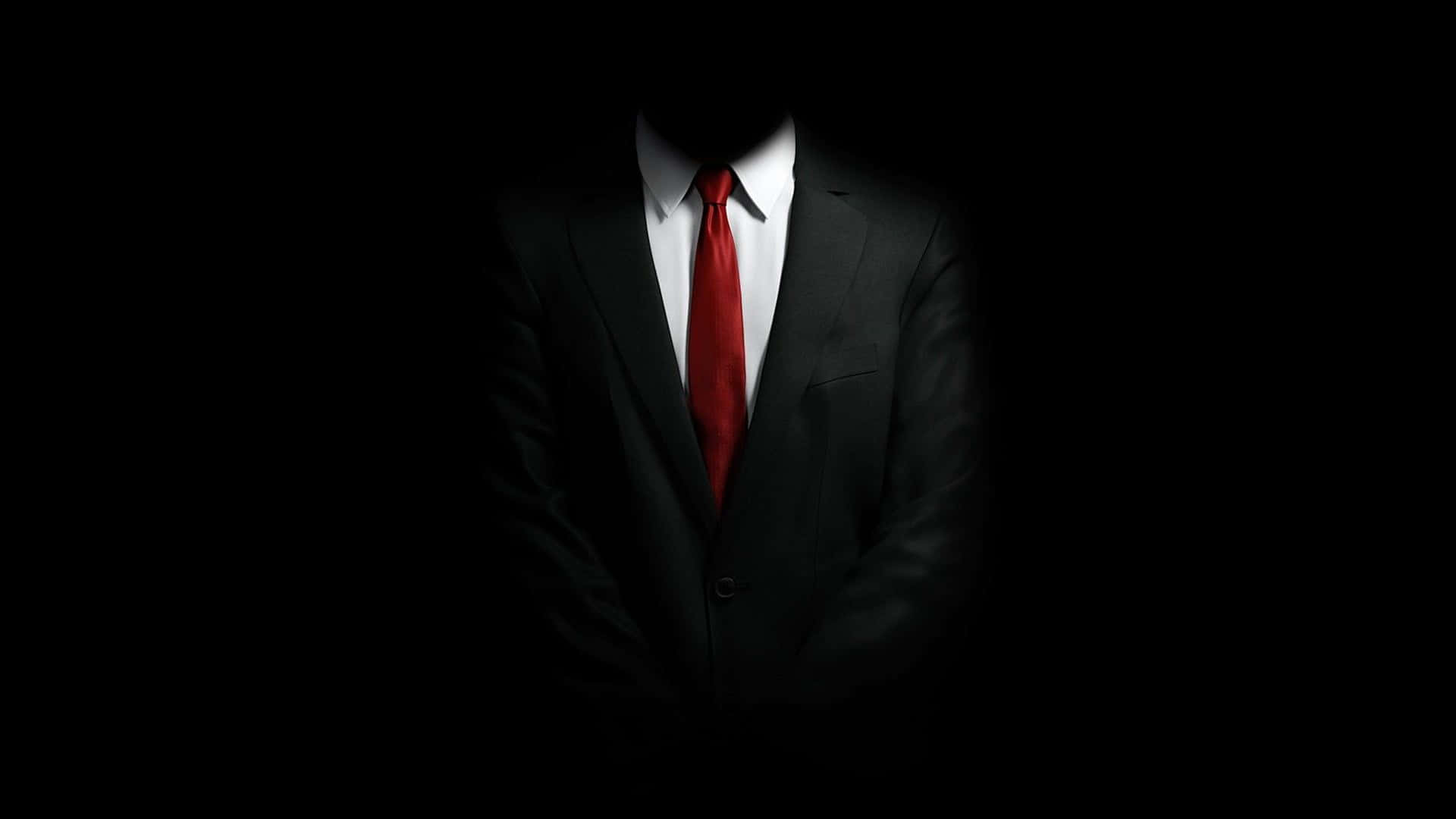 A Man In A Suit And Tie Is Standing In The Dark