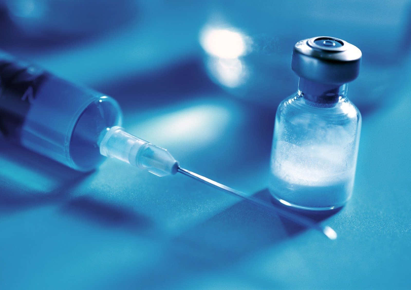 High-definition image of medical syringe and tiny bottle Wallpaper
