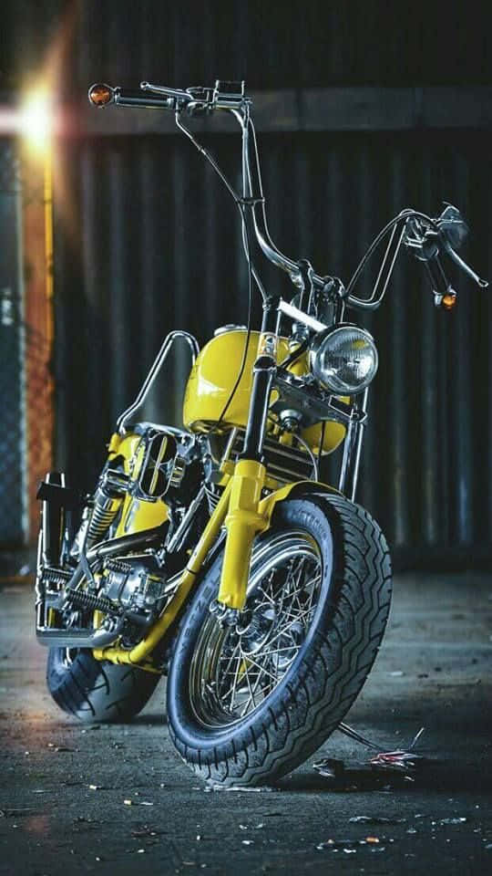 A Yellow Motorcycle Parked In A Dark Garage Wallpaper