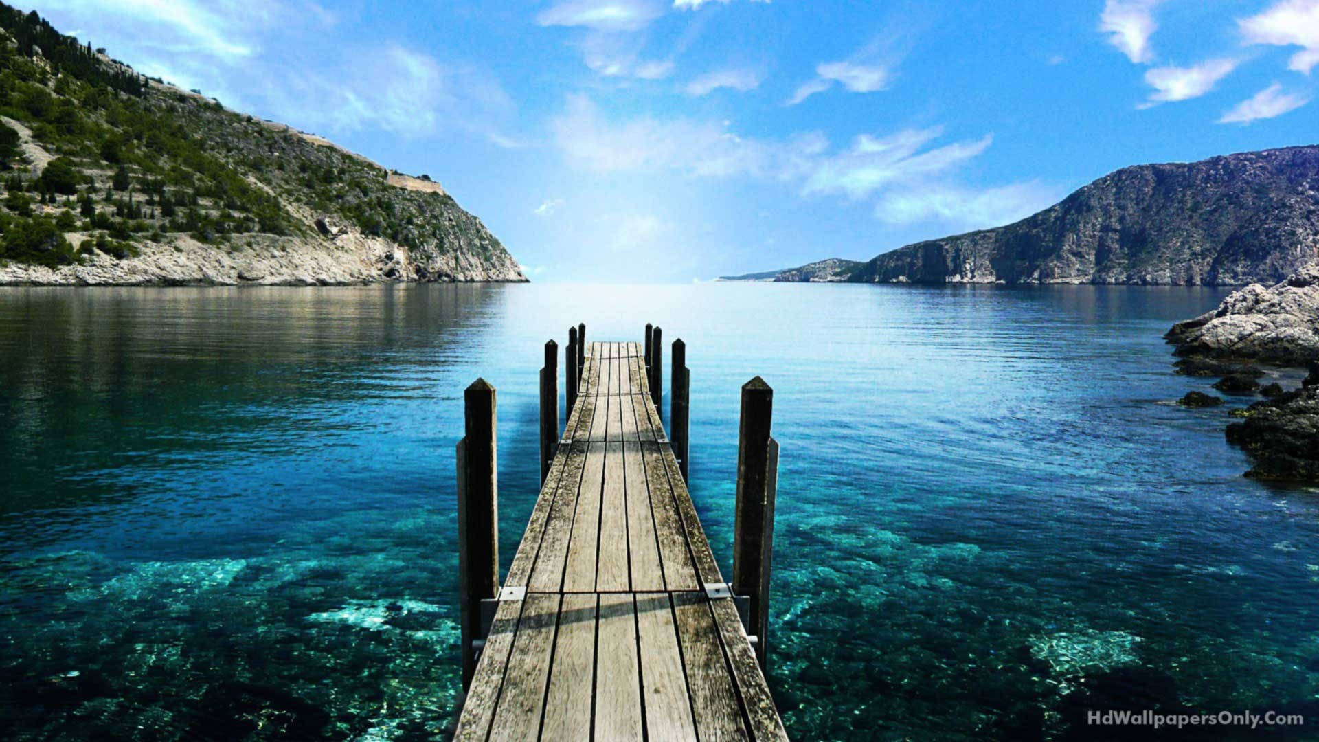 HD wallpaper of wooden dock on clear blue ocean. 