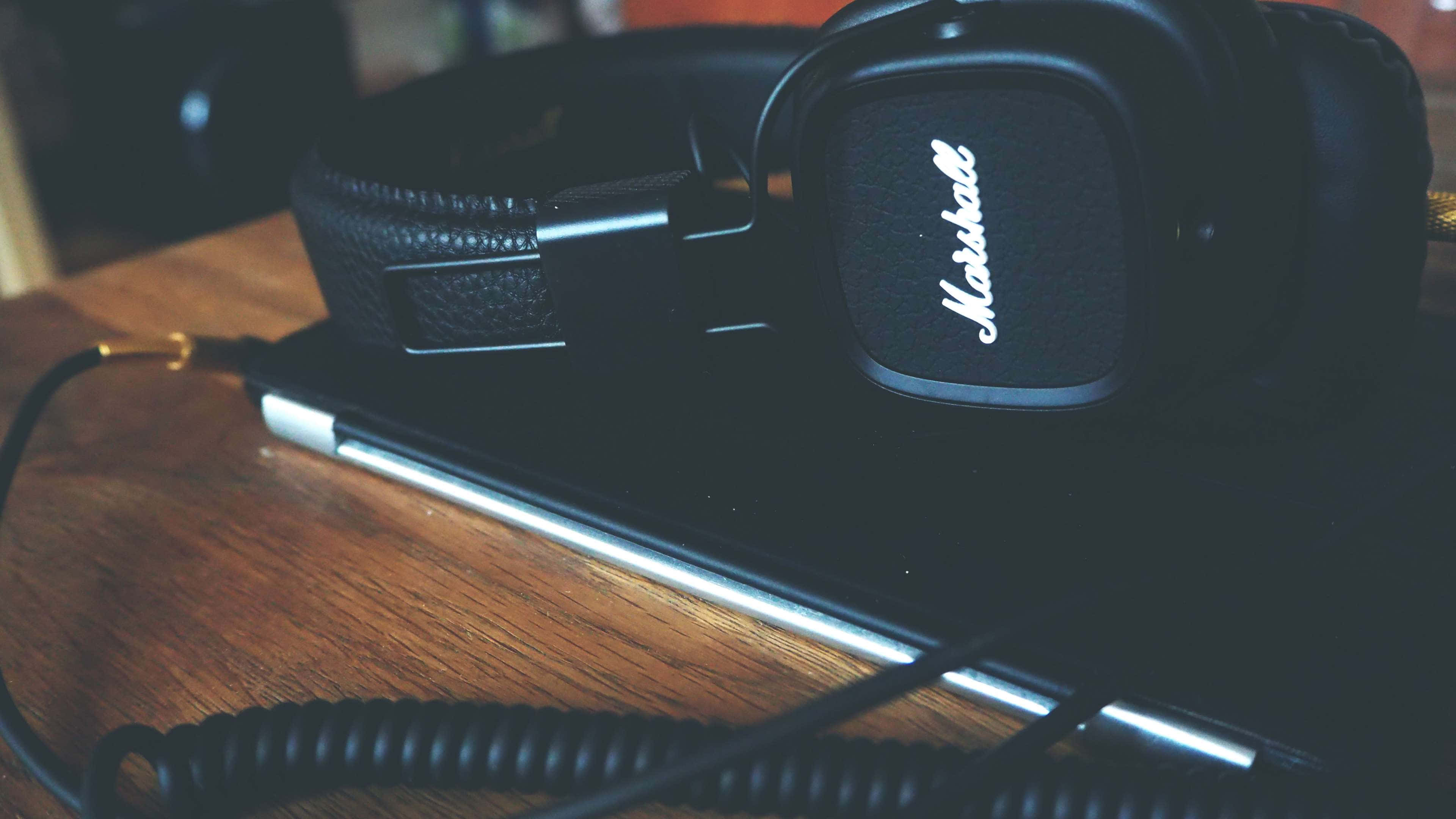 Get things done and enjoy your music with a laptop and headphones Wallpaper