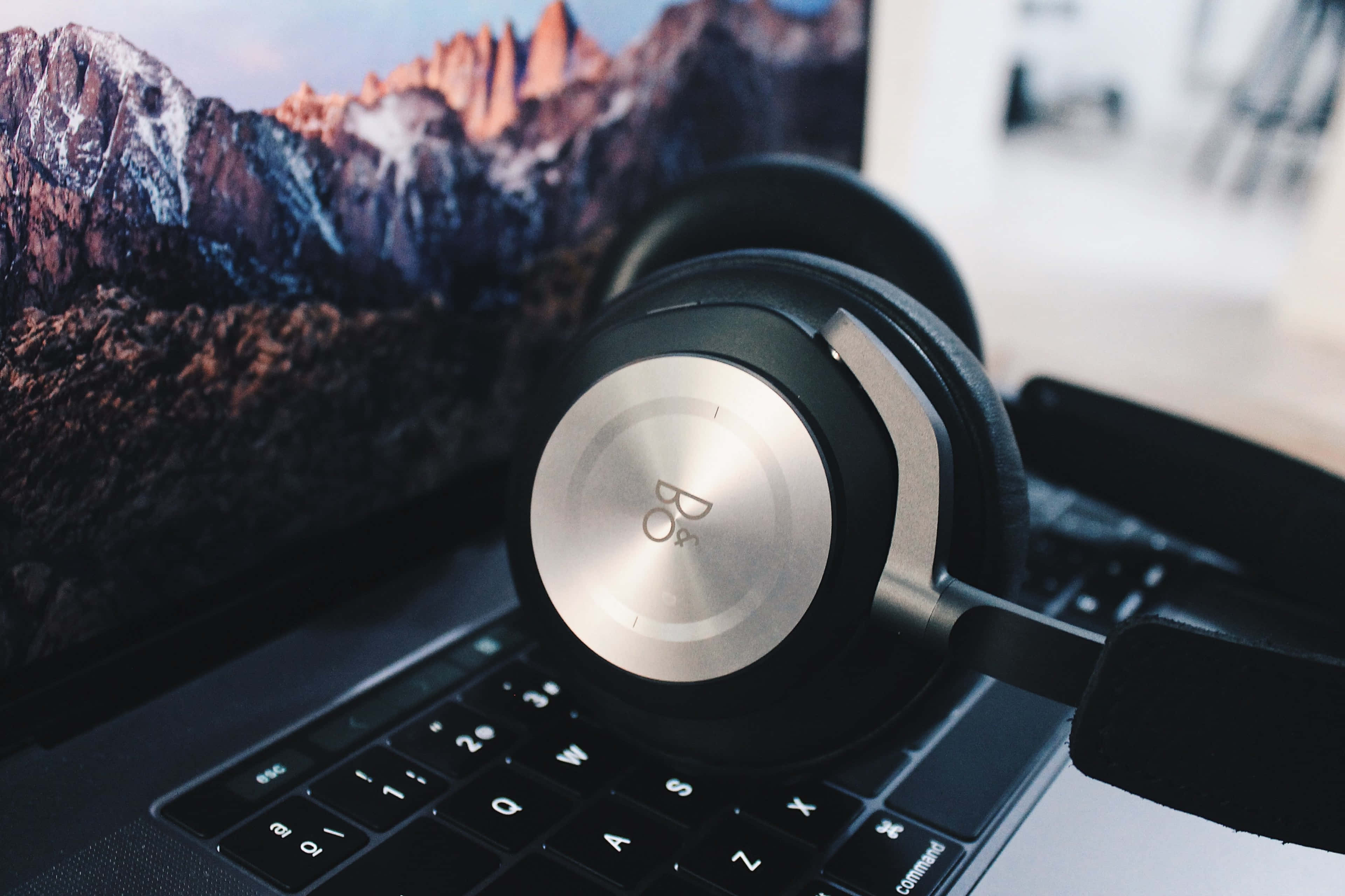 A pair of headphones beside a laptop Wallpaper