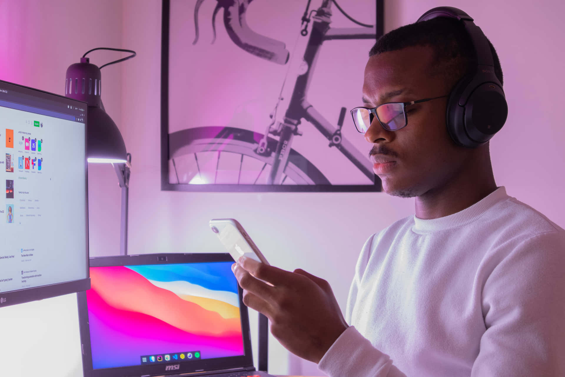 A Man Wearing Headphones Is Using His Phone At Home Wallpaper