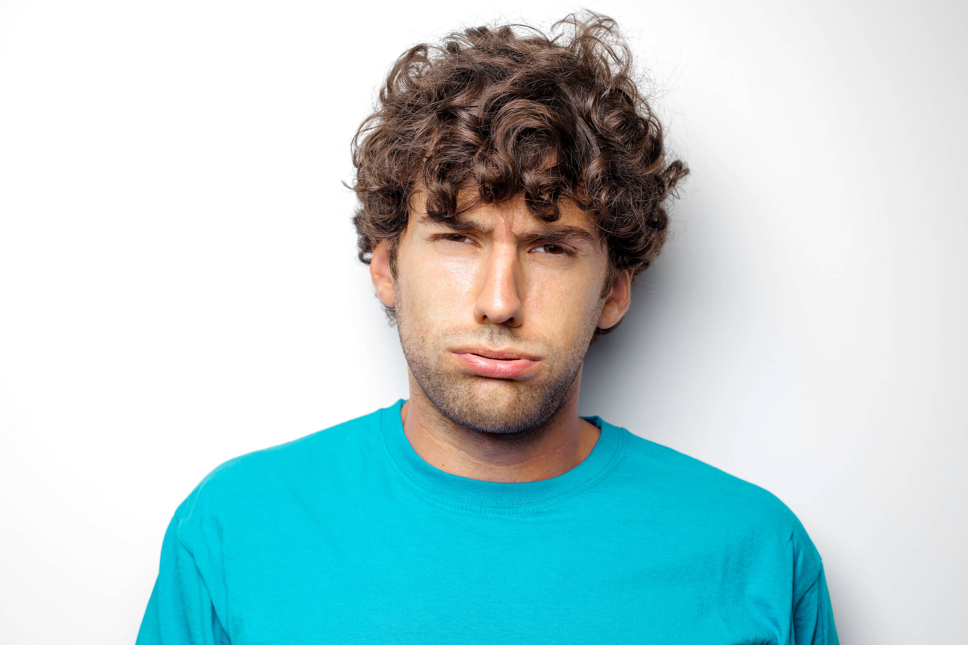 Headshot Of An Exhausted Man With Curly Hair Wallpaper