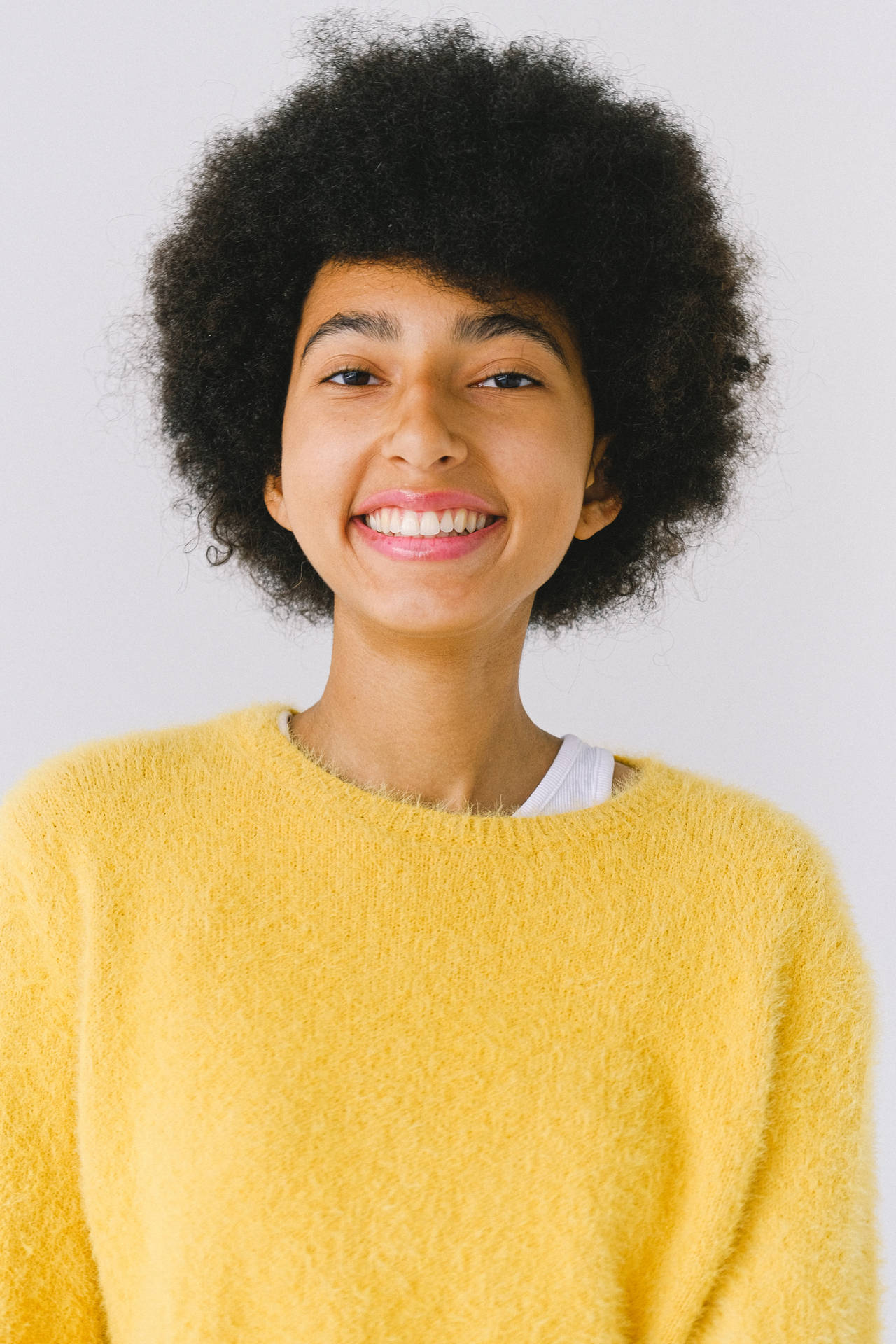 Headshot Of Black Woman In Yellow Knitted Top Wallpaper
