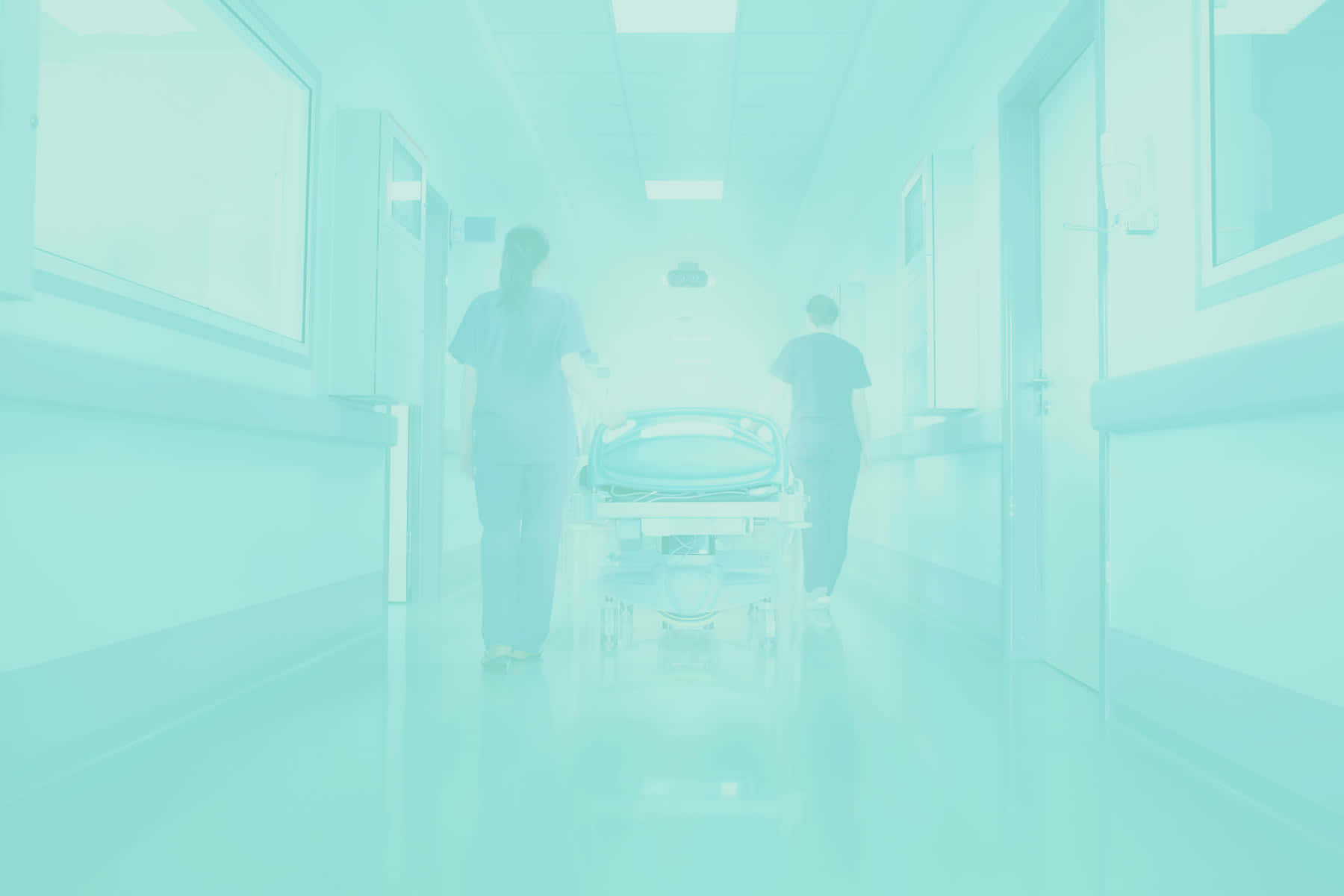A Hospital Hallway With A Blue Background And Two People Walking Down It