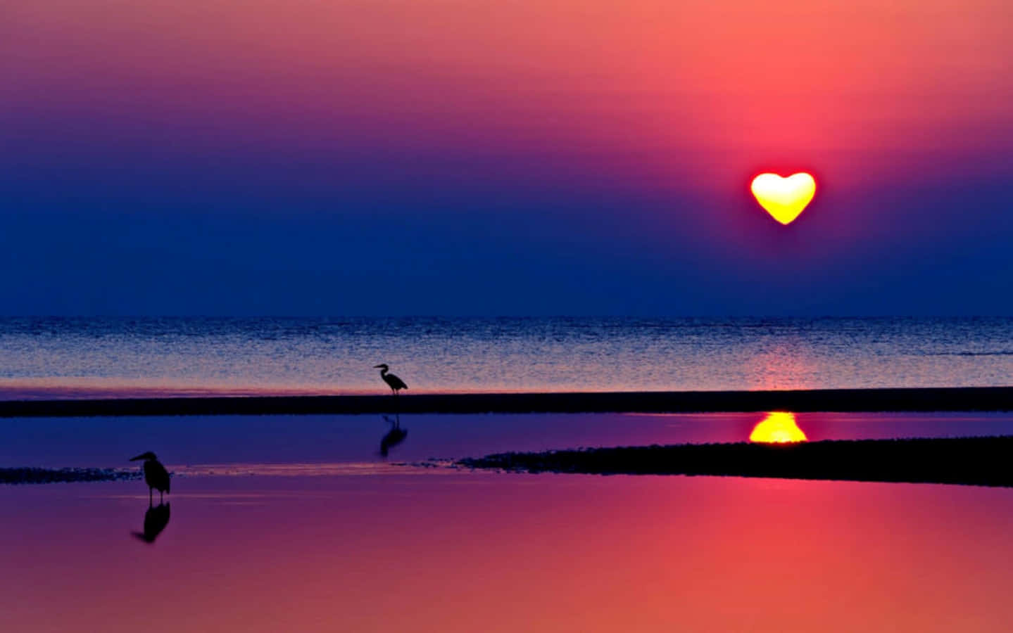 A Radiant Heart Silhouette in the Sunset Sky Wallpaper