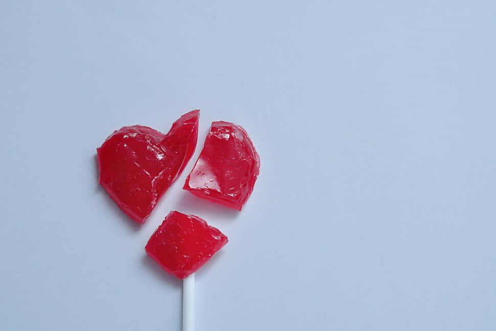 En rød hjerteformet lollipop på en pind