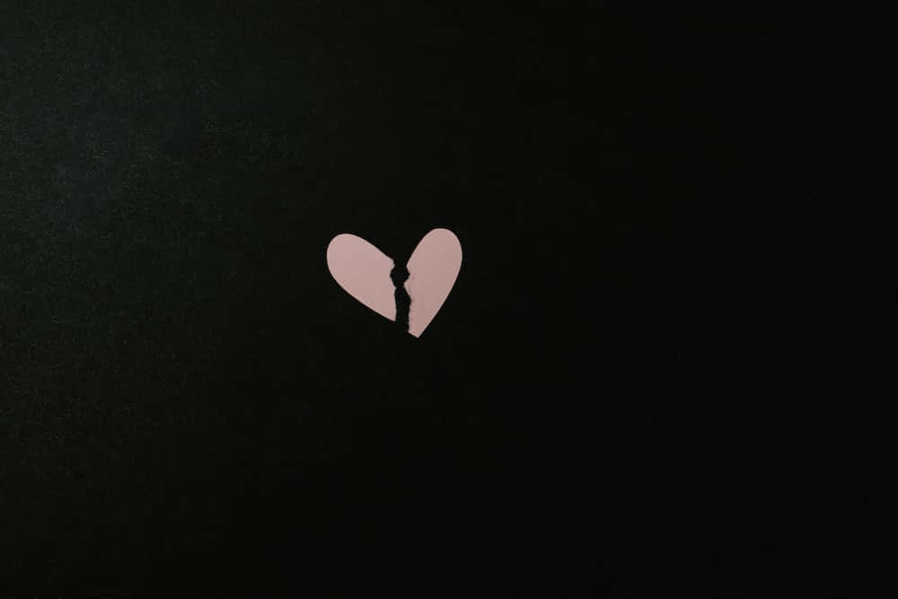 Et hjerte med et knust stykke i det på en sort baggrund