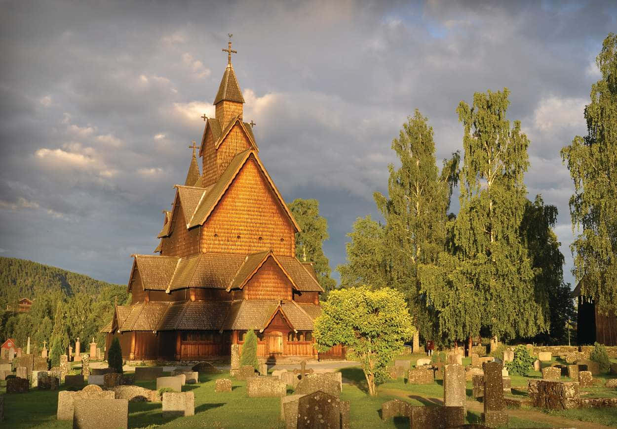 Majestic Heddal Stave Church Against the Backdrop of a Golden Sky Wallpaper