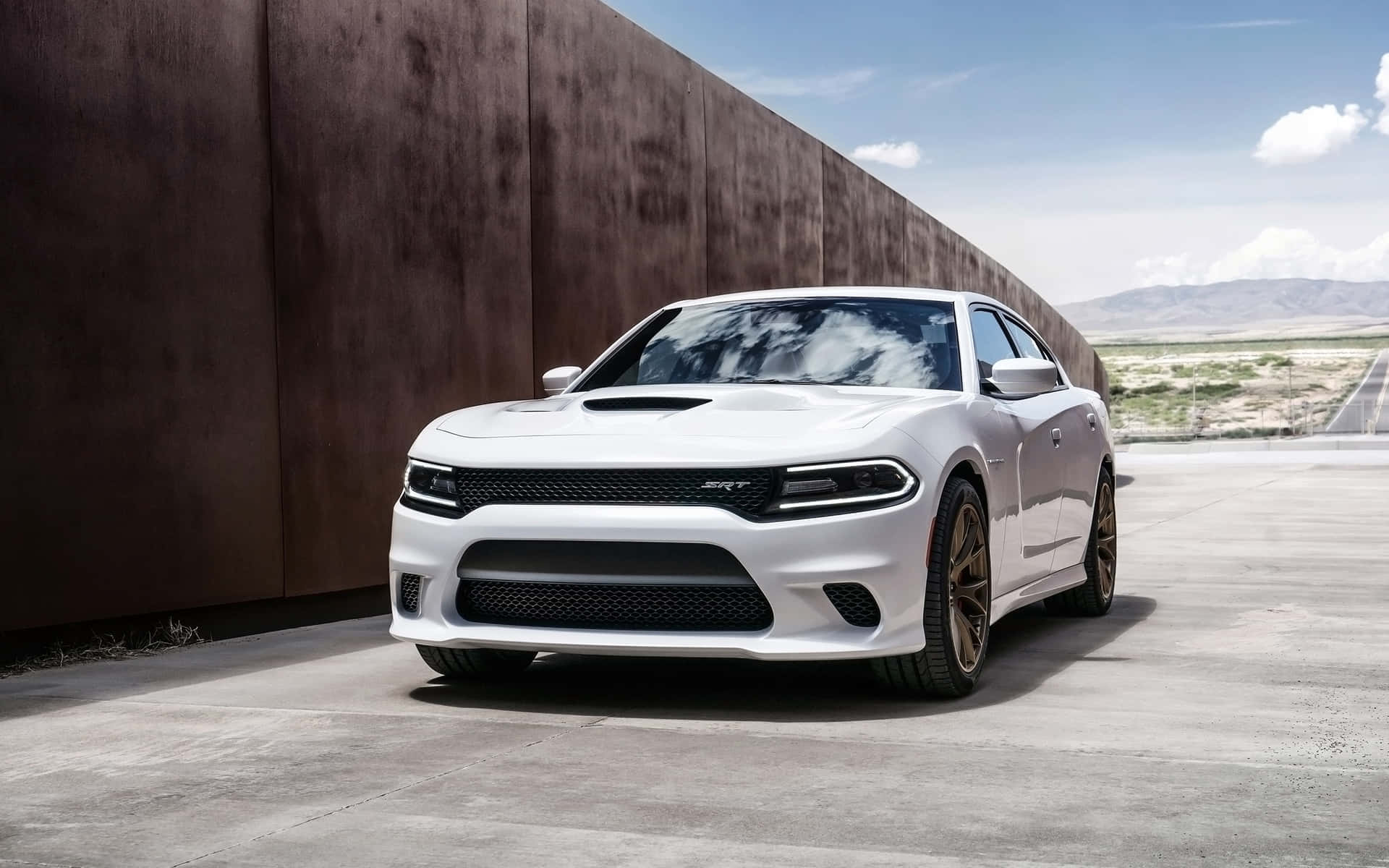 The White Dodge Charger Srt Parked In Front Of A Wall Wallpaper