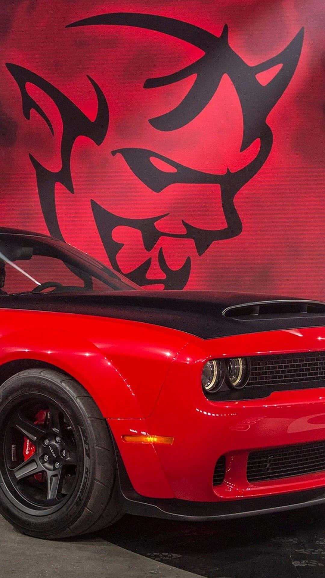 Umdodge Challenger Vermelho Está Estacionado Na Frente De Um Mural Com O Diabo. Papel de Parede