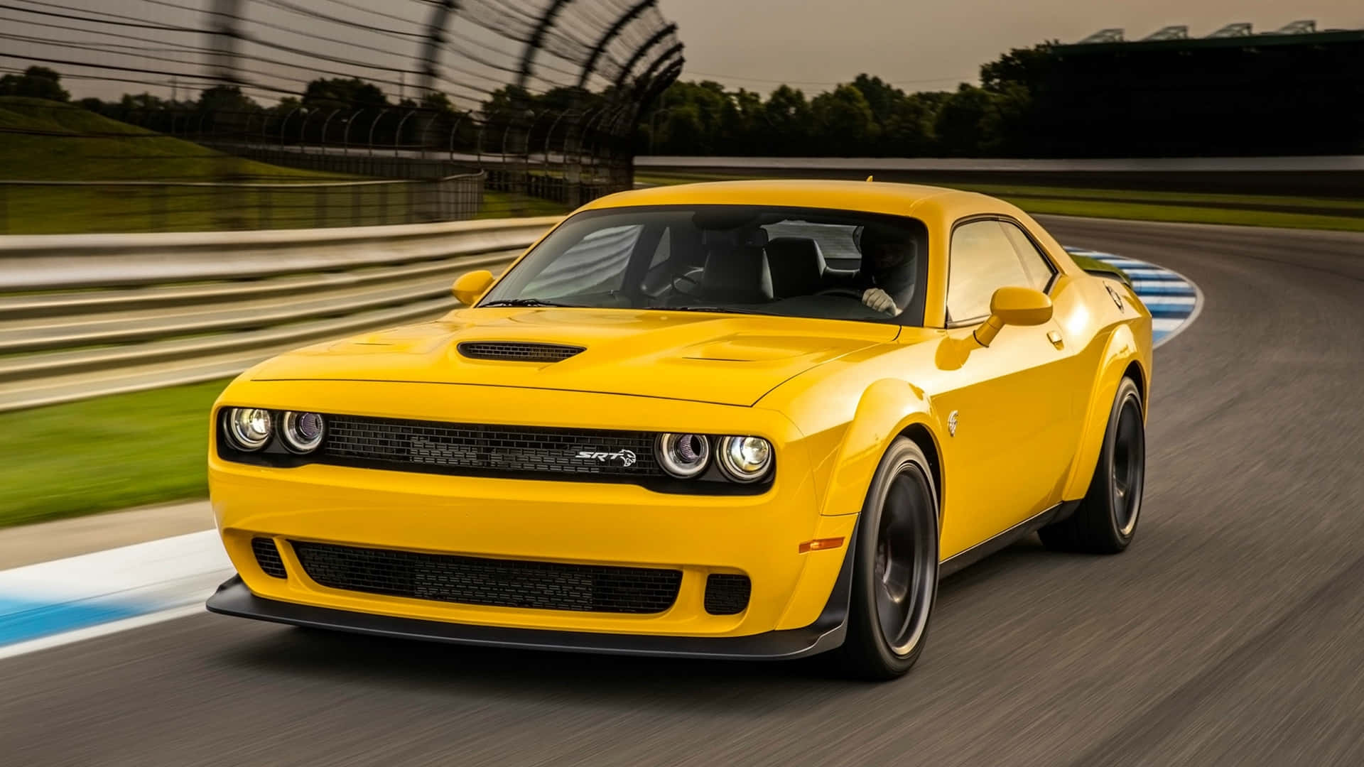 The Yellow Dodge Challenger Is Driving On A Race Track Wallpaper