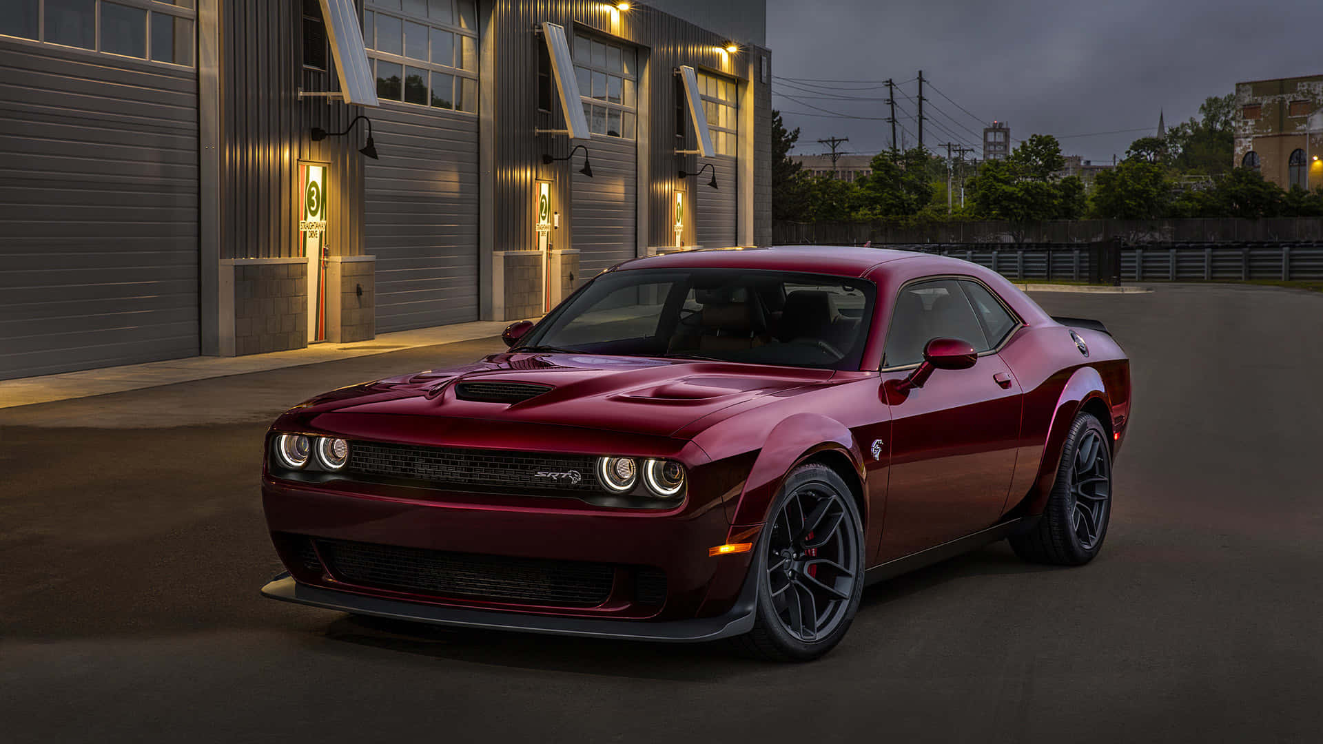 The Red 2019 Dodge Challenger Srt Is Parked In Front Of A Garage Wallpaper