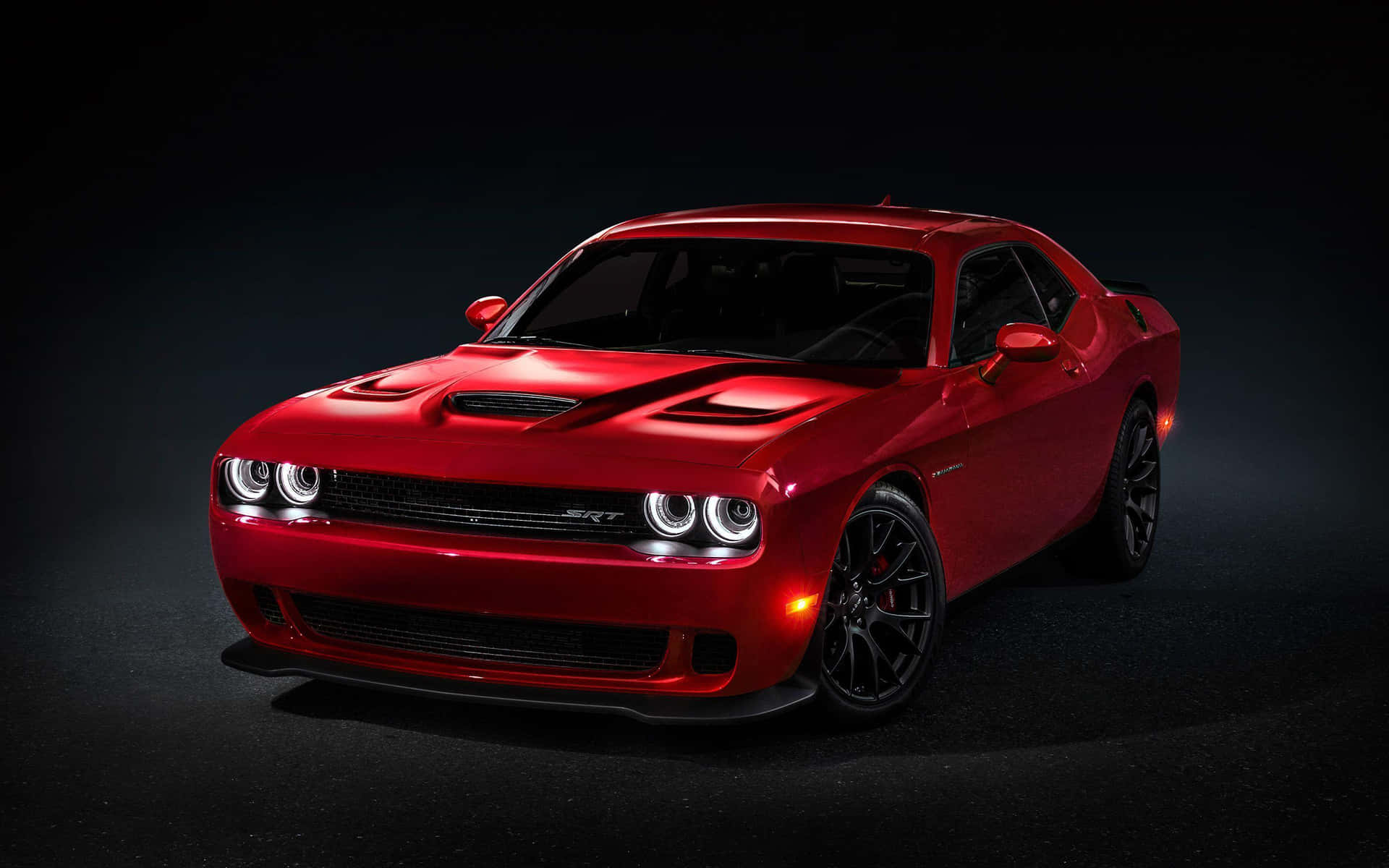 The Red Dodge Challenger Is Shown In A Dark Room Wallpaper