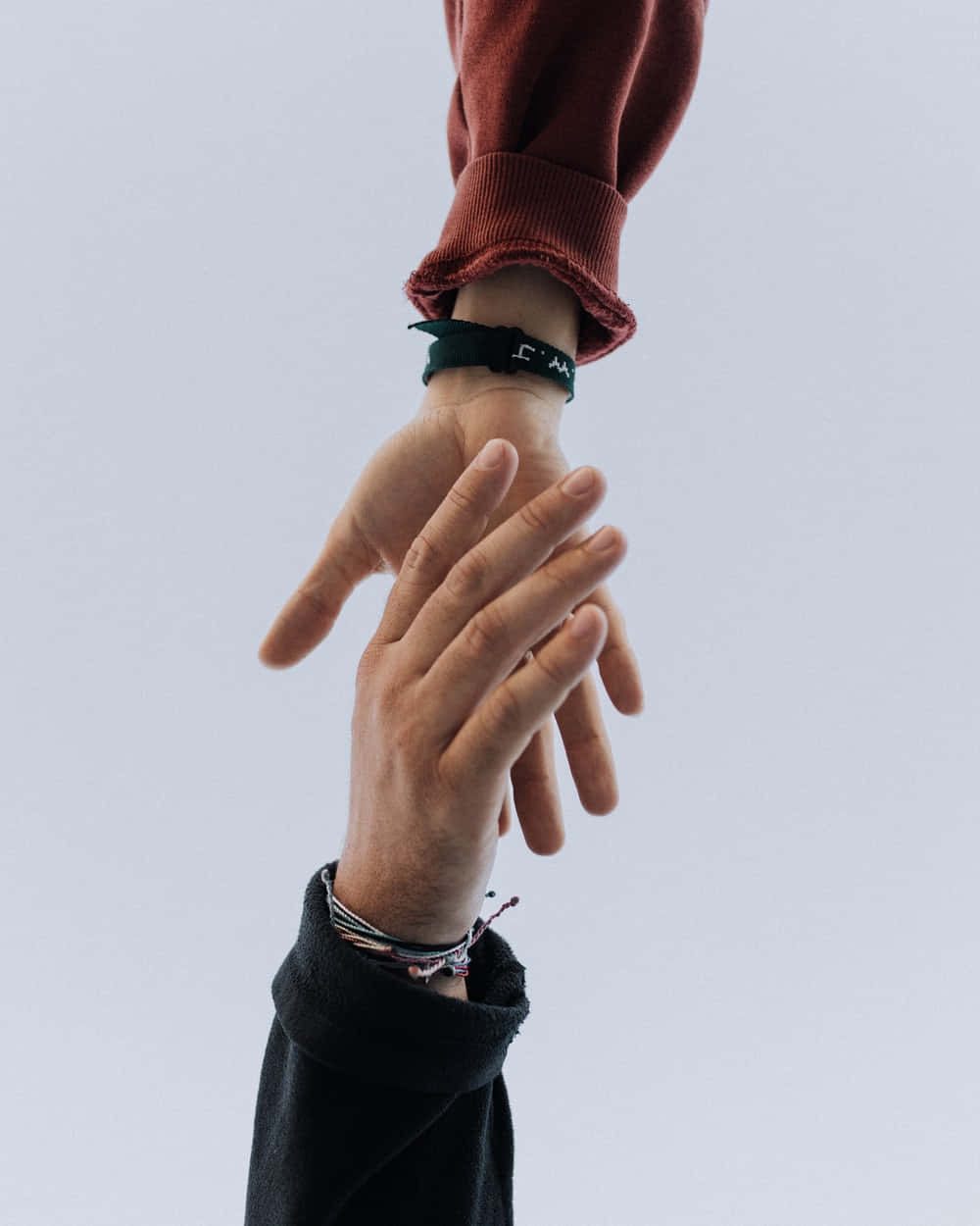 Two People Holding Hands In The Air