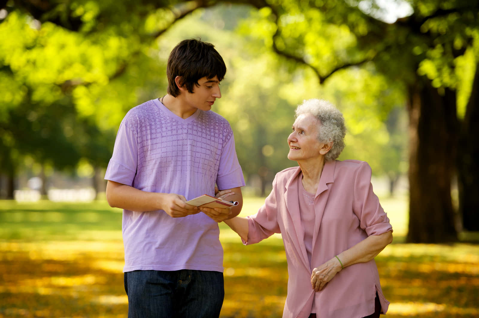 A Young Man And An Older Woman Talking In A Park