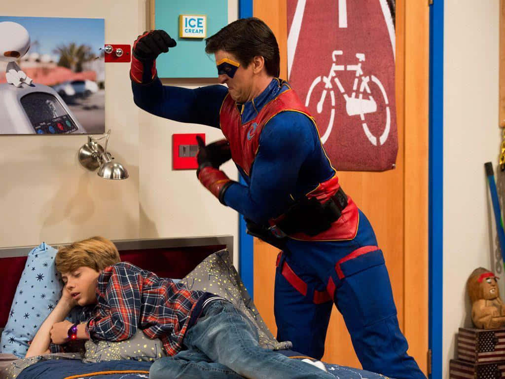 En dreng i en superhero kostume kæmper med en anden dreng i et soveværelse Wallpaper