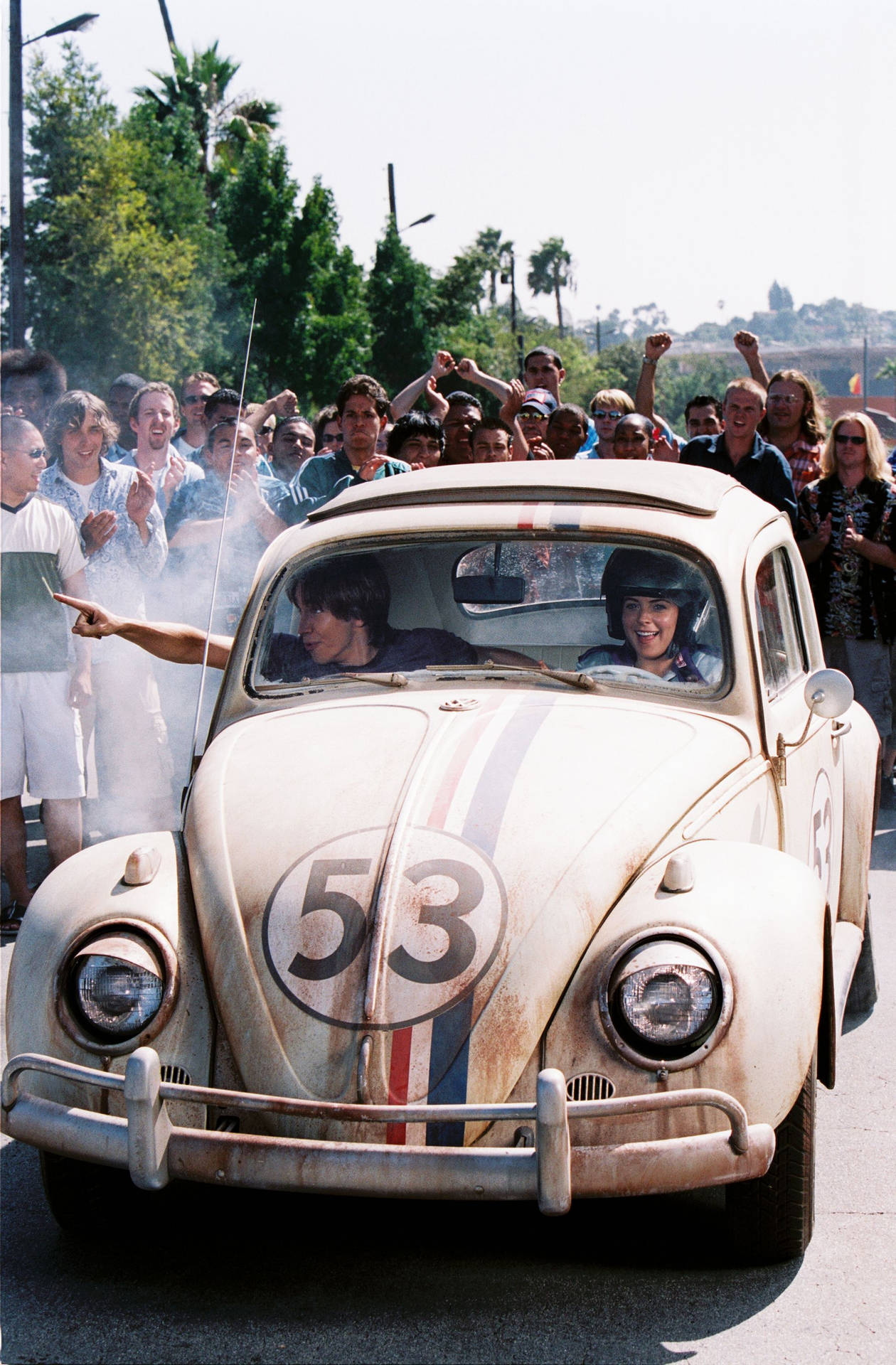 Herbie Fully Loaded Driving Couple In Crowd Wallpaper