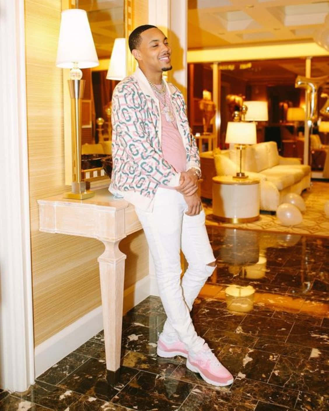A Man In White Pants And Pink Jacket Standing In A Room Wallpaper