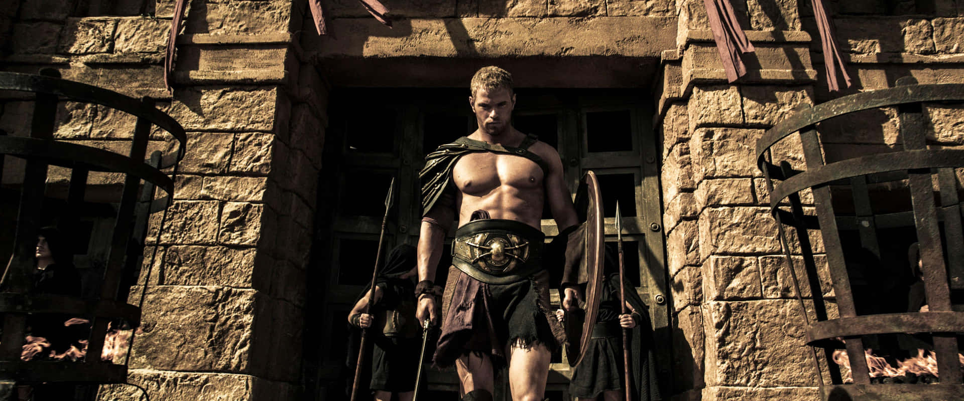 A Man In A Spartan Costume Standing In Front Of A Stone Building
