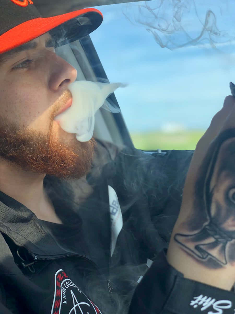 A Man Smoking A Cigarette In A Car Wallpaper
