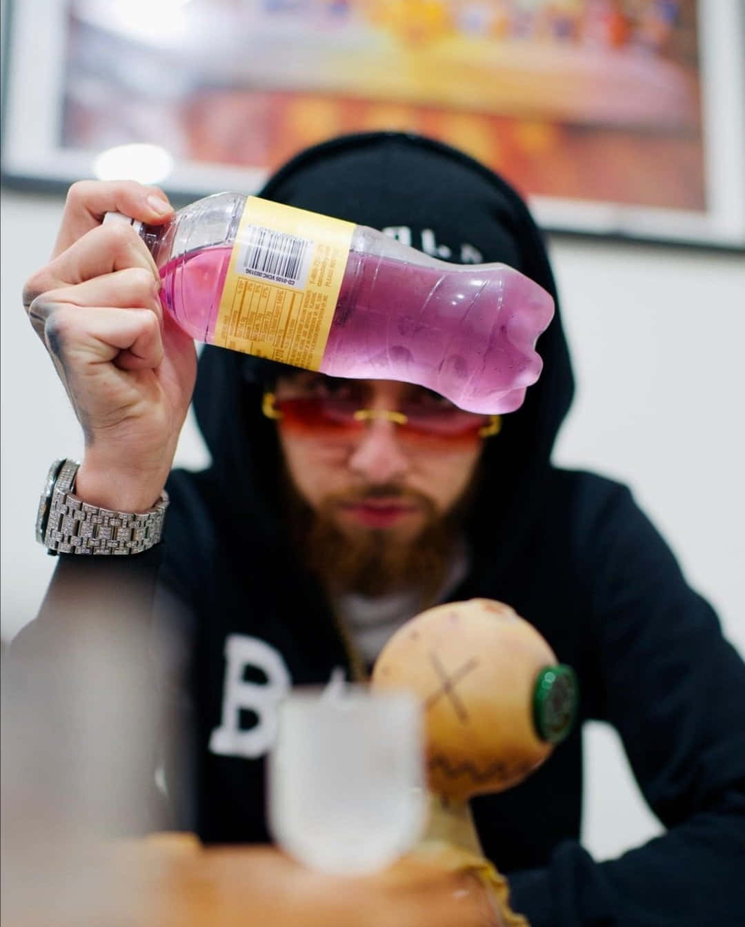 A Man Holding A Bottle Of Pink Liquid Wallpaper