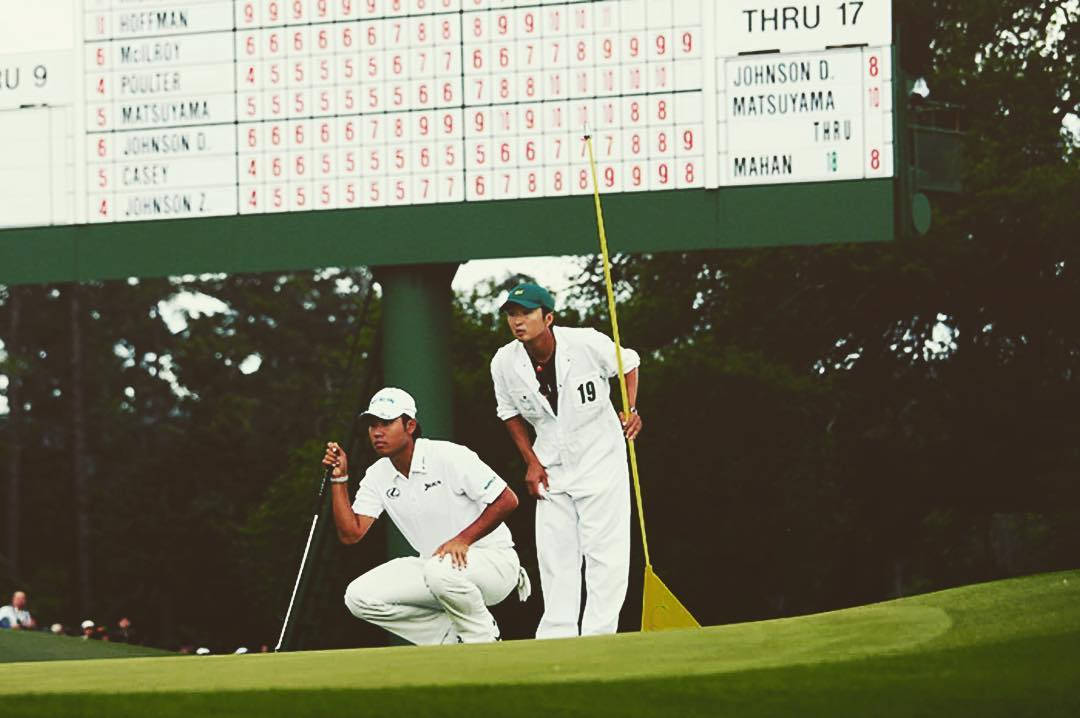 Hideki Matsuyama og caddie ser på hullet på golfbanen. Wallpaper