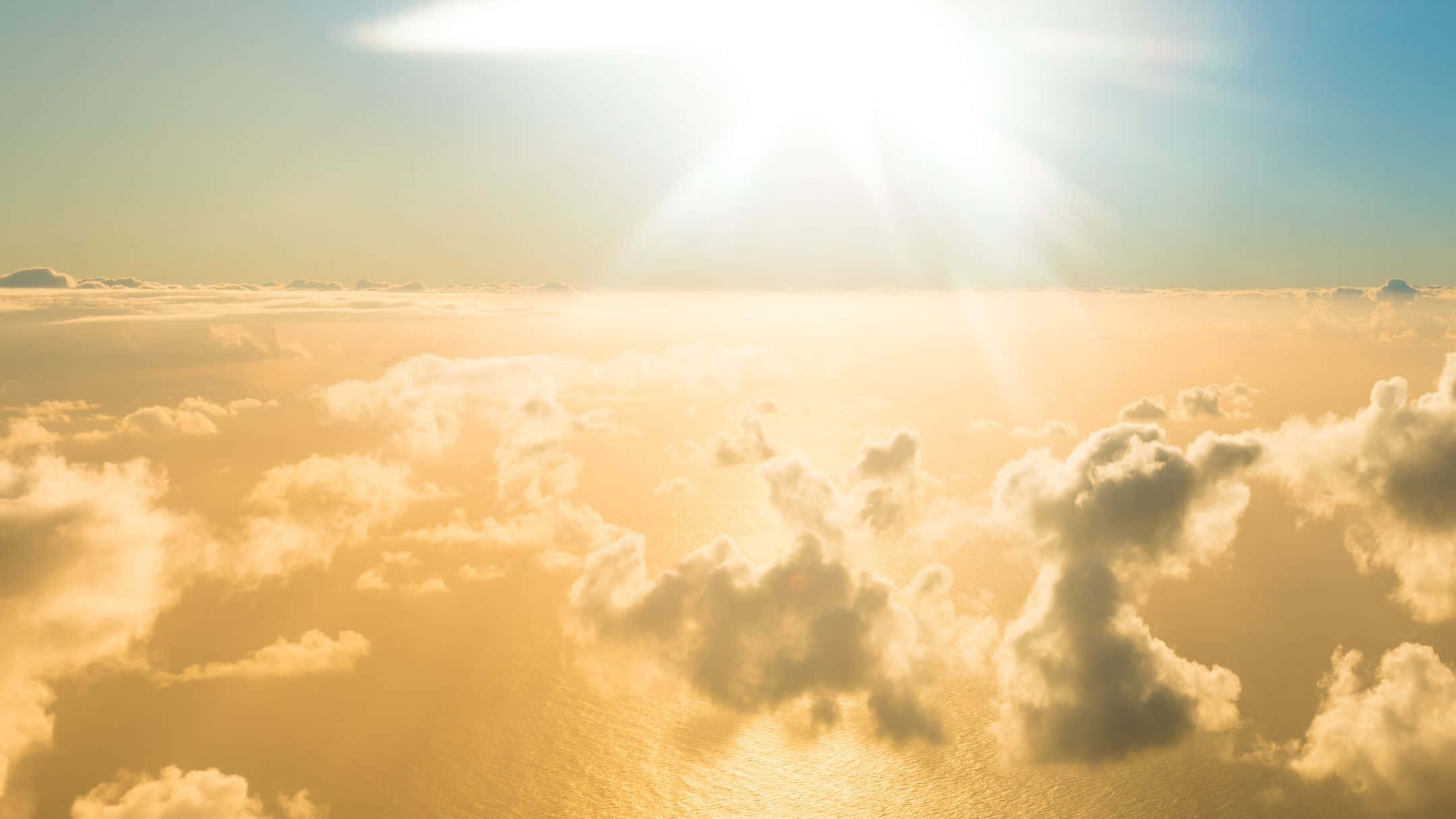 A Sun Shining Through Clouds Above The Ocean