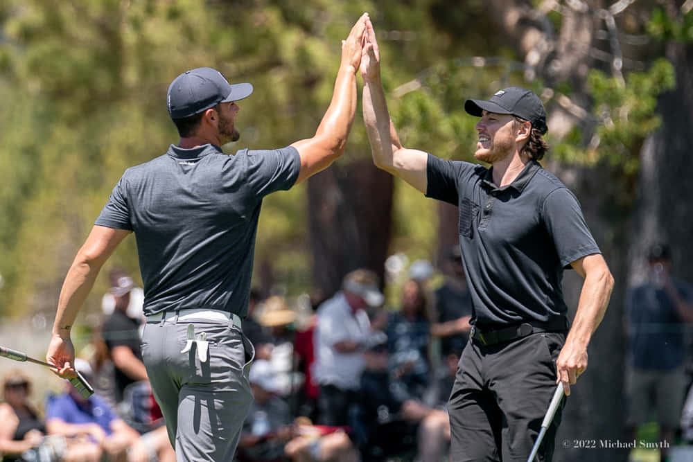 Two Golfers High Five Each Other During A Tournament