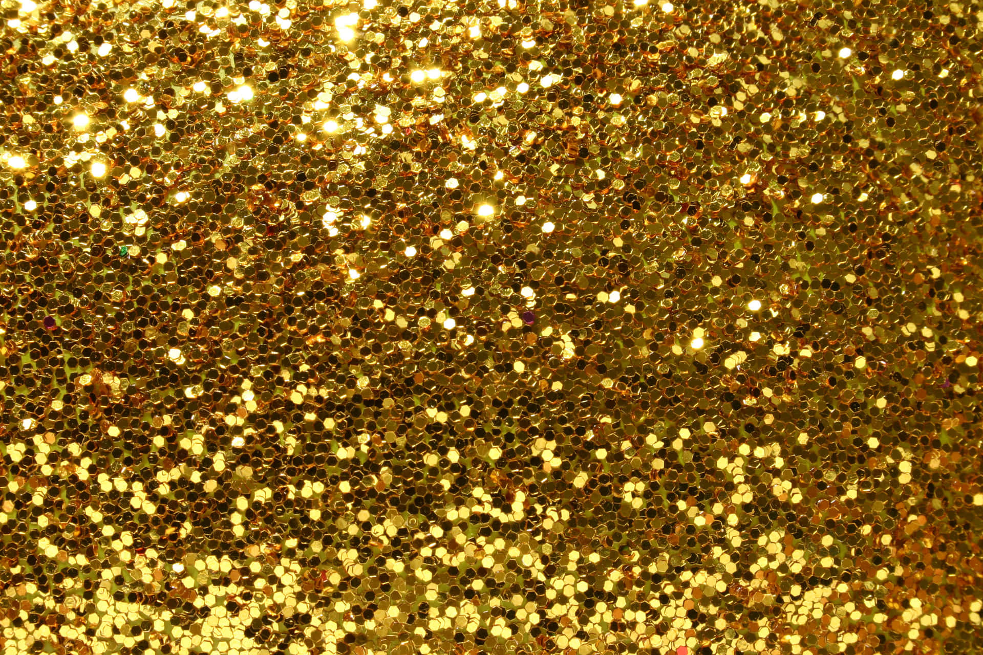 A Gold Glitter Background With A Lot Of Sparkles
