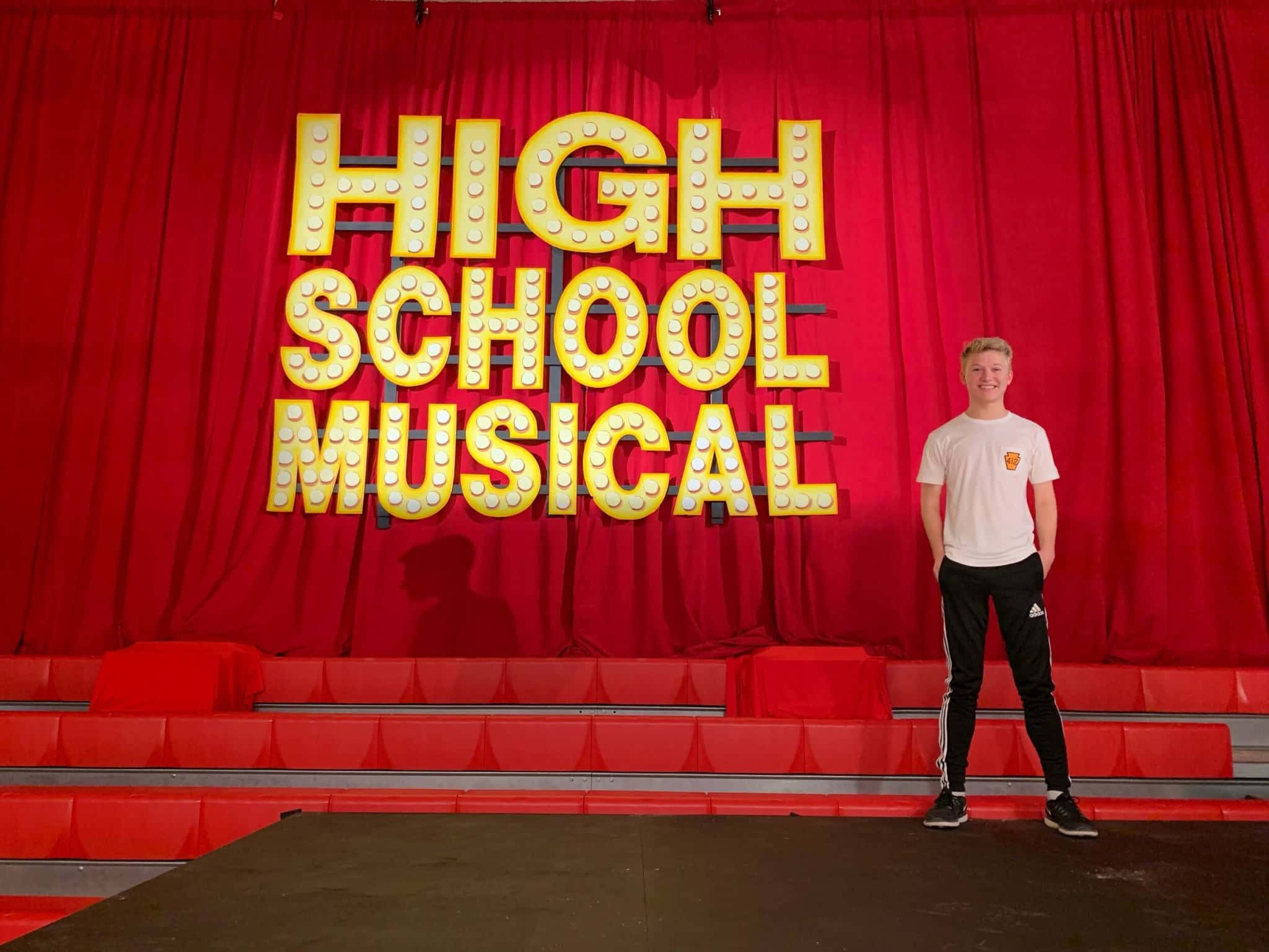 Caption: The High School Musical cast dancing and singing in a memorable scene