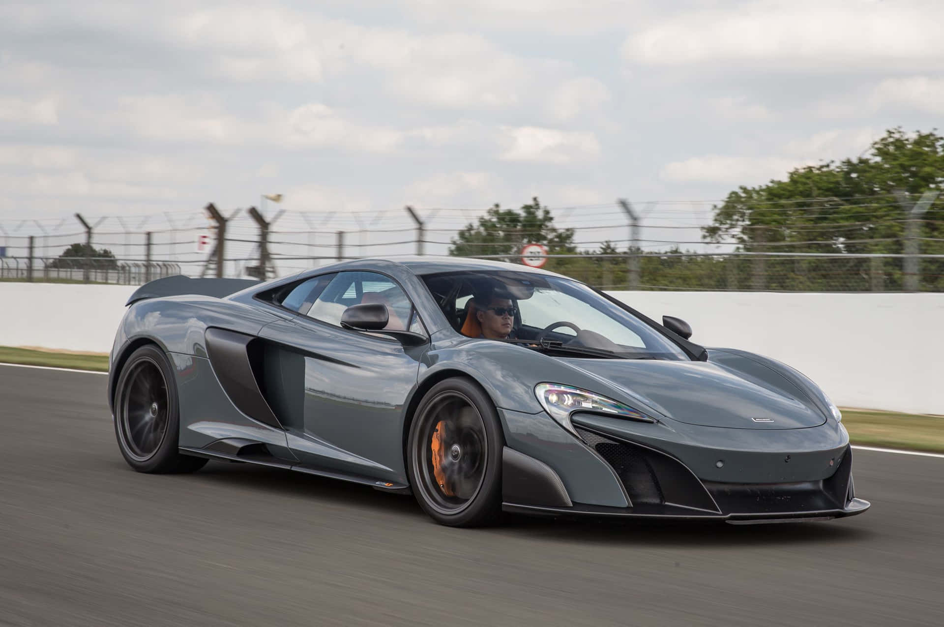 High-speed Chase: Immaculate Mclaren 675lt On The Open Road Wallpaper