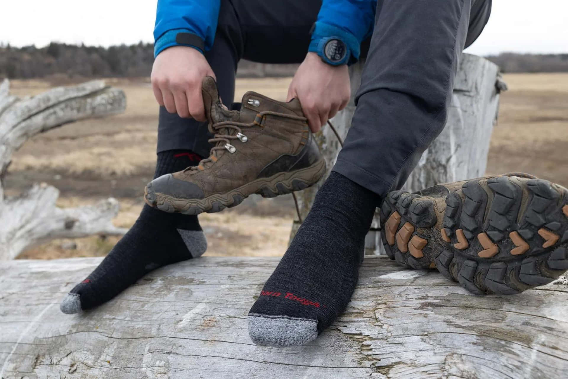 Hiker Putting On Socks Outdoors Wallpaper