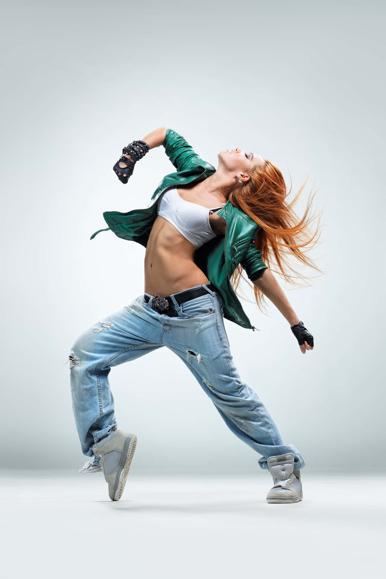 A Woman In Jeans And A Green Jacket Is Dancing